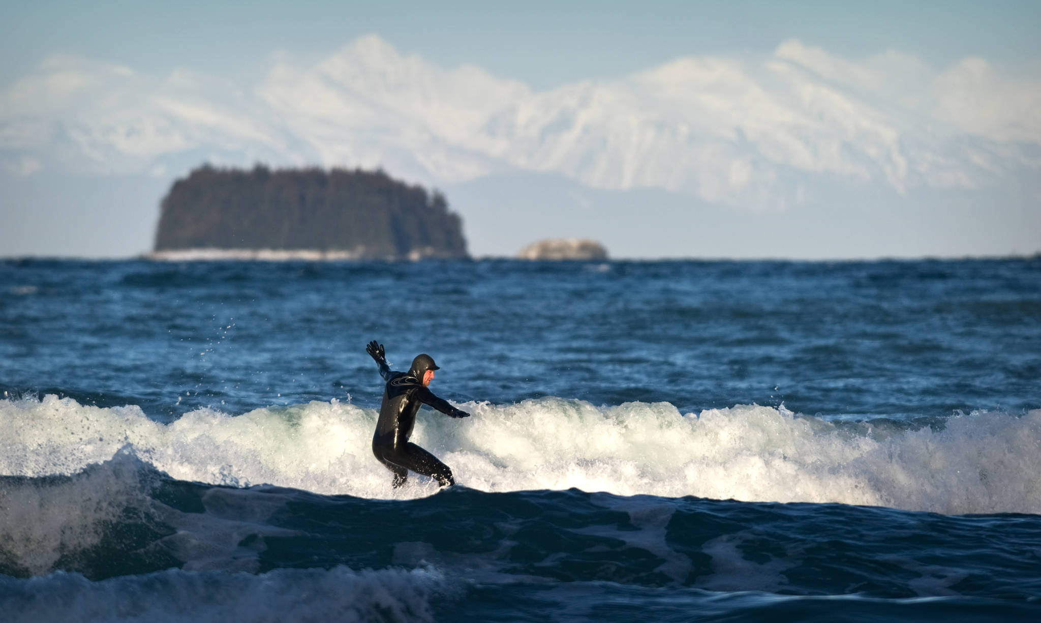 In this February 2015 photo, Chris Hinkley takes advantage of high winds from the north to surf off Lena Beach. (Michael Penn | Juneau Empire File)