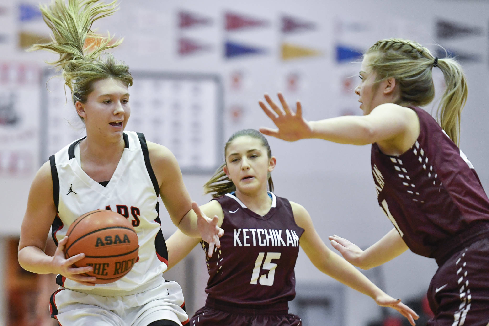 Juneau-Douglas’ Caitlin Pusich, left, drives against Ketchikan’s Madison Rose, center, and Ashley Huffine at JDHS on Friday, Feb. 22, 2019. JDHS won 56-38. (Michael Penn | Juneau Empire)
