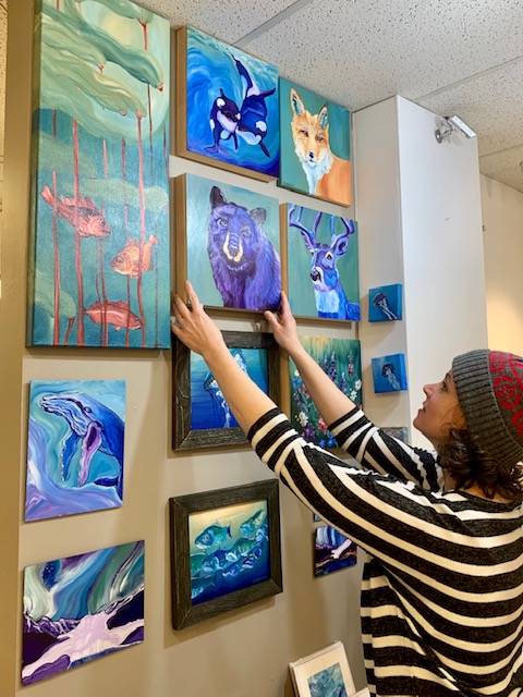 Christine Kleinhenz hangs some of her work at Juneau Artists Gallery ahead of a grand reopening planned for March 1, 2019. (Courtesy photo | Juneau Artists Gallery)