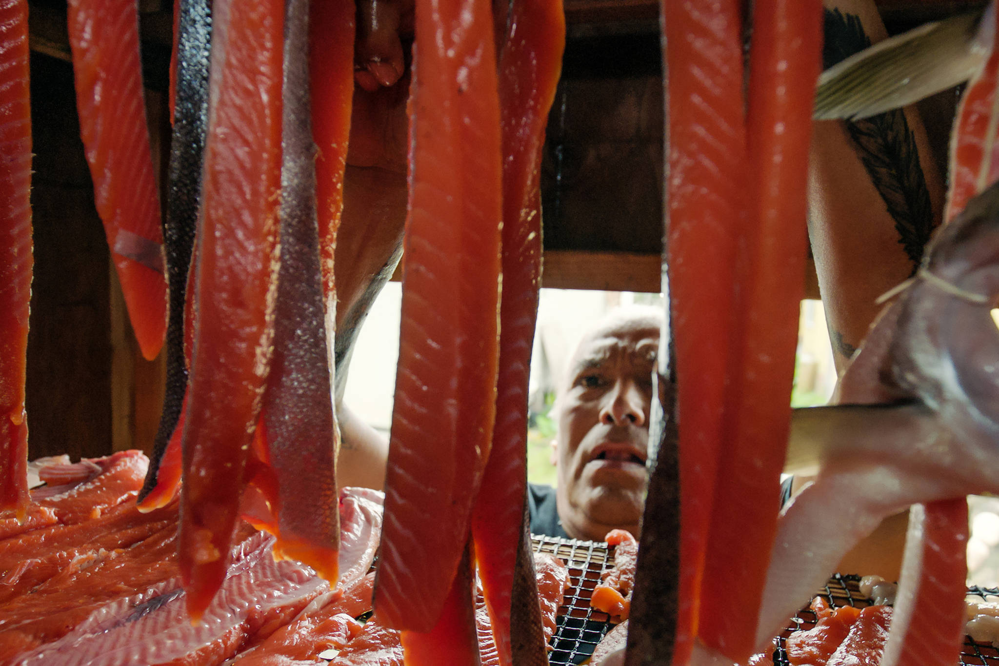 Anthony Gastelum hangs fresh caught salmon in the smokehouse in the village of Kake. (Courtesy photo | Ben Hamilton)