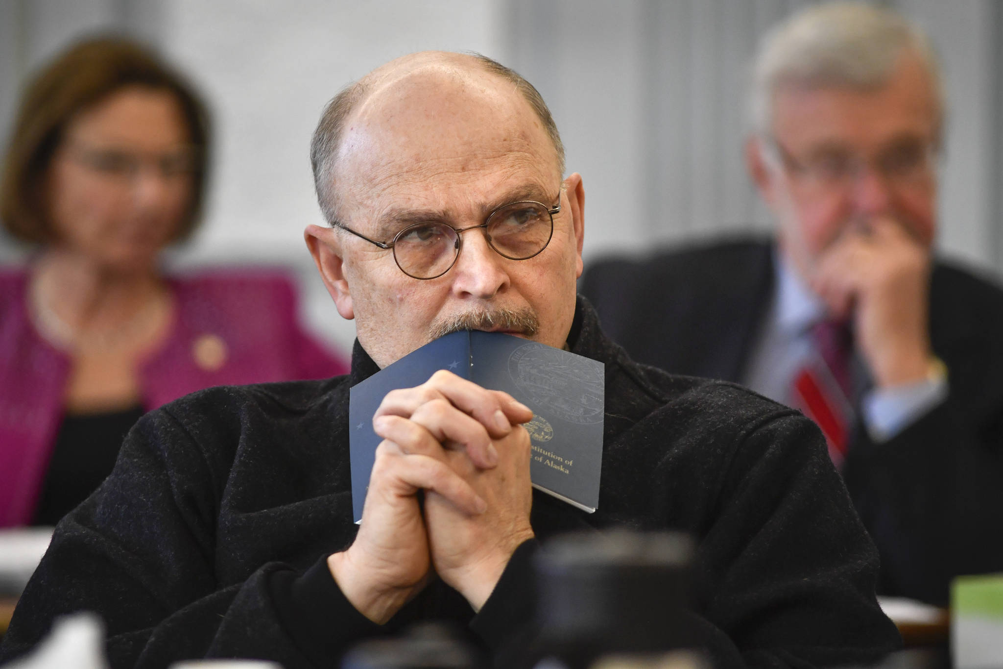 Sen. Click Bishop, R-Fairbanks, rests his head on a Constitution of Alaska booklet as he listens to Donna Arduin, Director of the Office of Management and Budget, and Mike Barnhill, policy director for the OMB, present Gov. Mike Dunleavy’s budget to the Senate Finance Committee at the Capitol on Tuesday, Feb. 18, 2019. Senate President Cathy Giessel, R - Anchorage, left, and Sen. Gary Stevens, R-Kodiak, right, are in the background. (Michael Penn | Juneau Empire)