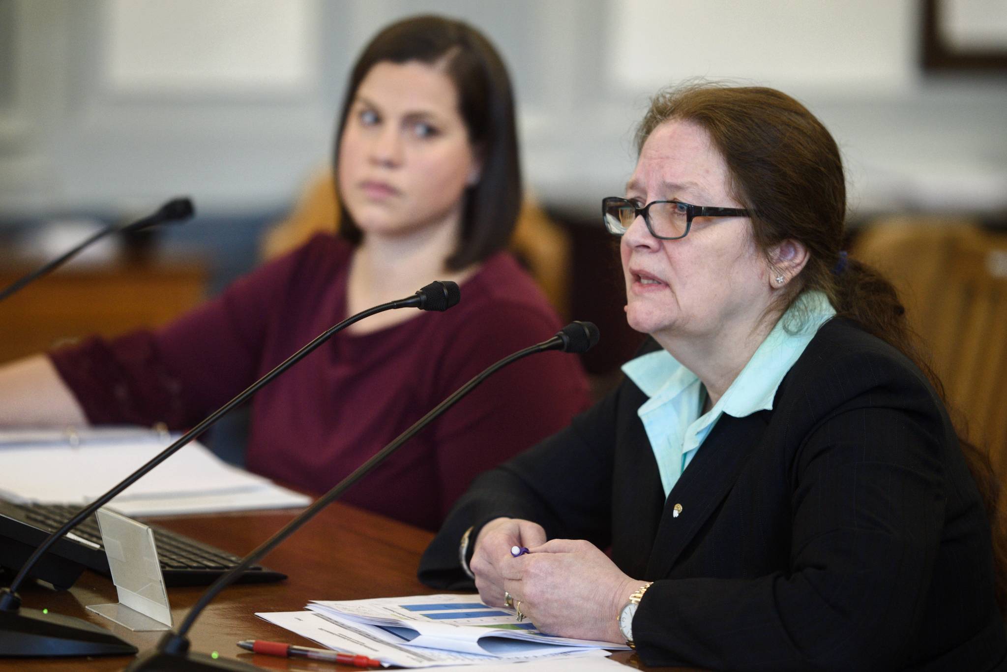 Cheryl Lowenstein, Director of the Division of Administration Services, left, speaks to the Senate Finance Committee with Lacey Sanders, Budget Director for the Office of Management and Budget, consolidation of departments on Monday, Feb. 25, 2019. (Michael Penn | Juneau Empire)