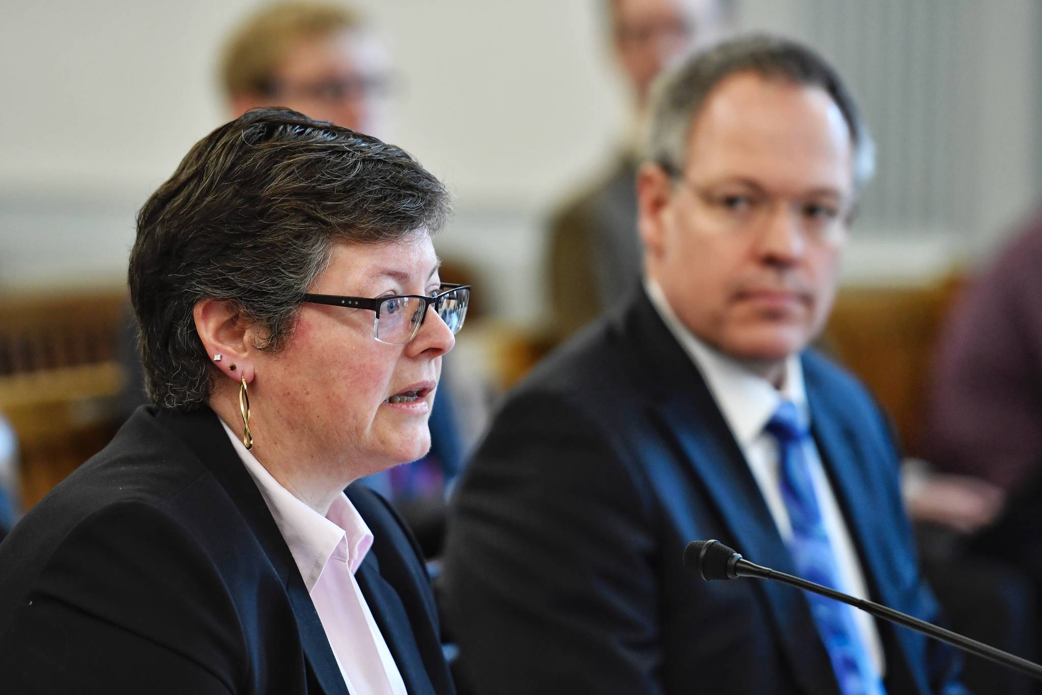 Michelle Prebula, an investment officer with the Department of Revenue, left, and Bruce Tangeman, Commissioner of Revenue, give a presentation on the state’s cash flow in front of the Senate Finance Committee on Thursday, Feb. 28, 2019. (Michael Penn | Juneau Empire)