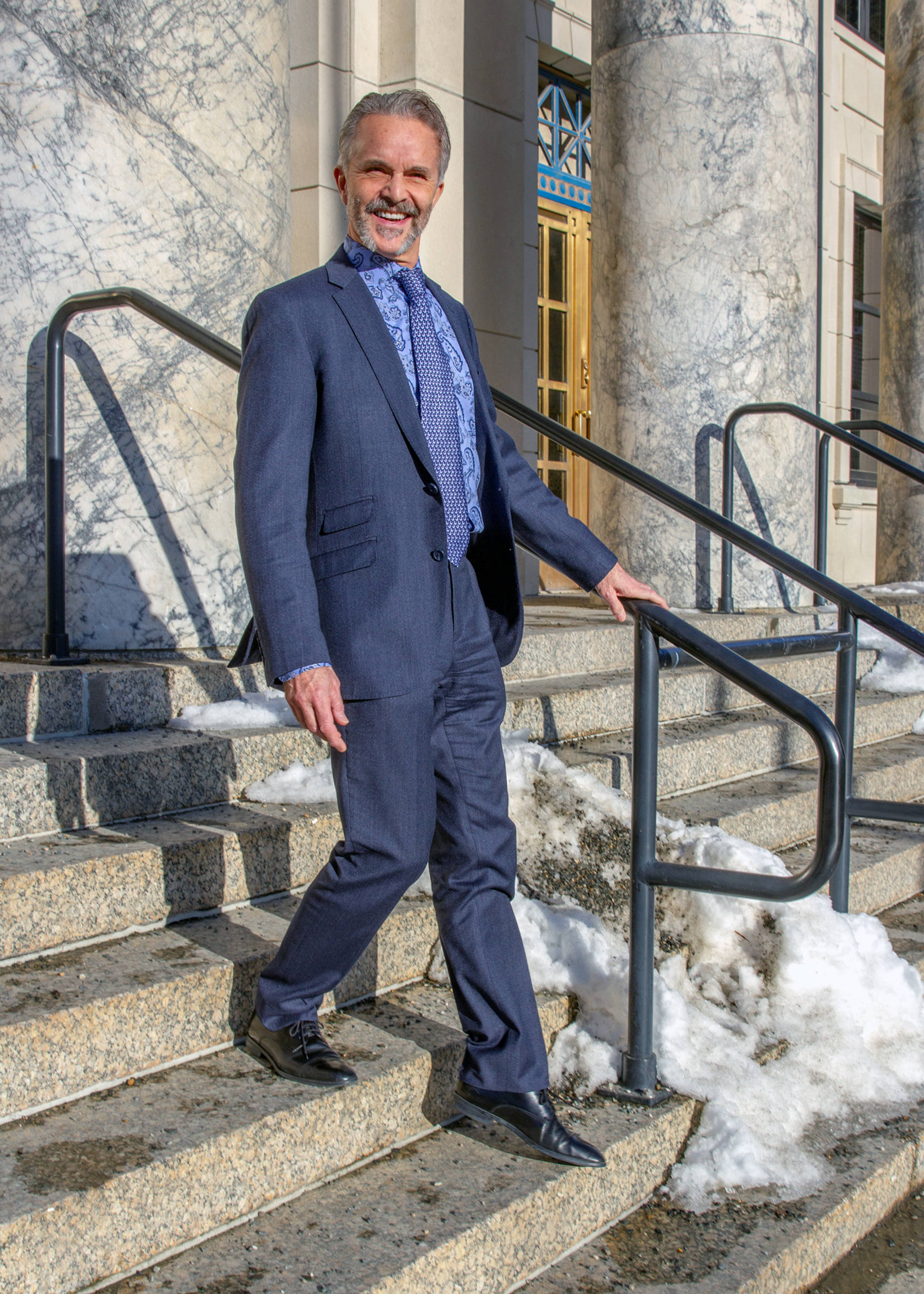 March 3, 2019: On the steps of the Capitol, Tom Atkinson, legislative staffer, cuts a fine form in his slim-cut wool suit from Trend Maxman. His suit coordinates impeccably with his cotton paisley shirt by Nordstrom, Italian silk neck tie from Andrew’s Ties and Brunomagli shoes, also made it Italy. (Kerry Howard | For the Juneau Empire)