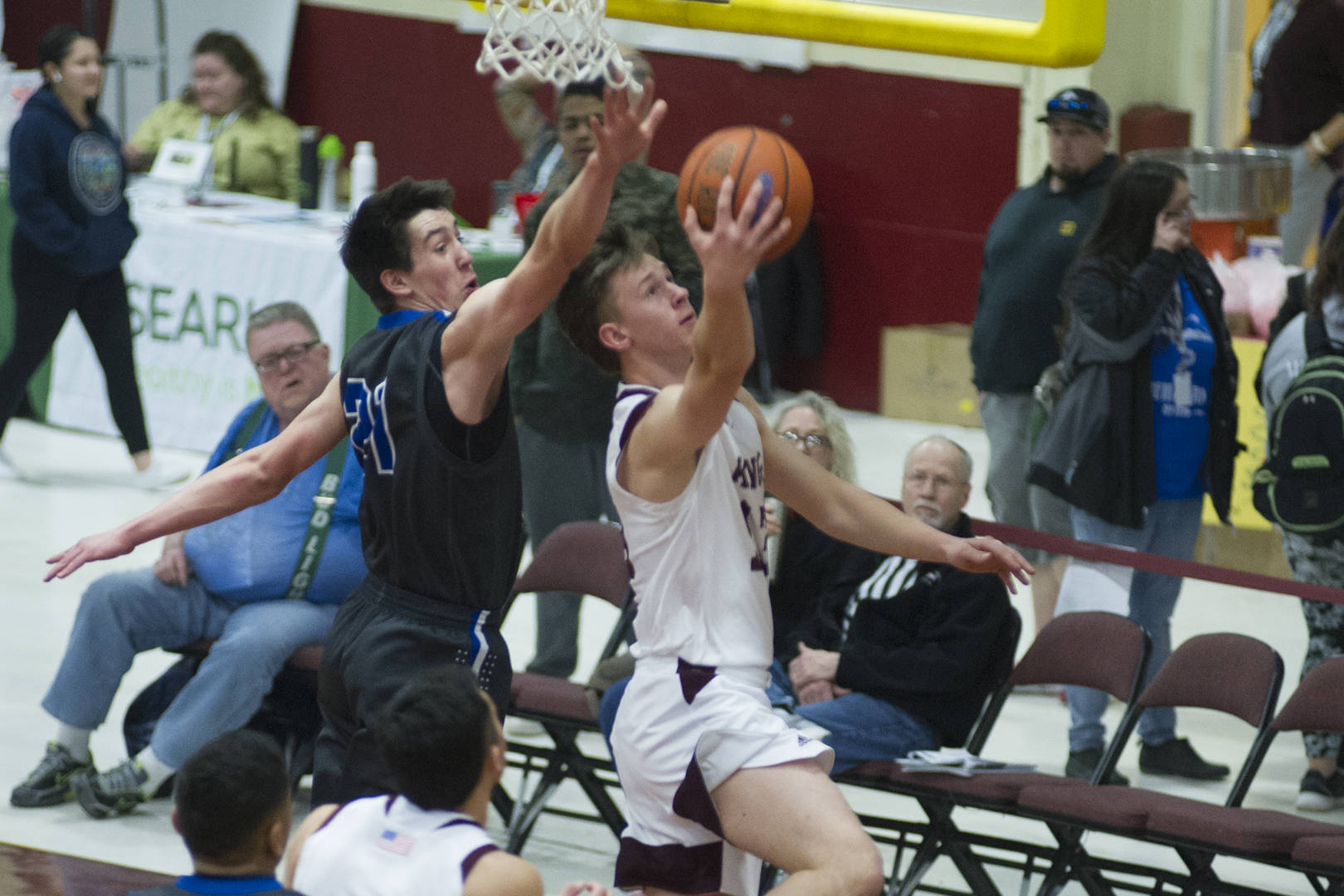 Ketchikan’s Cody Kemble lays the ball up while Thunder Mountain’s Braden Jenkins goes up for the block in the second round of the Region V 4A Tournament at the B.J. McGillis Gymnasium in Sitka. Ketchikan won 55-35. (Nolin Ainsworth | Juneau Empire)