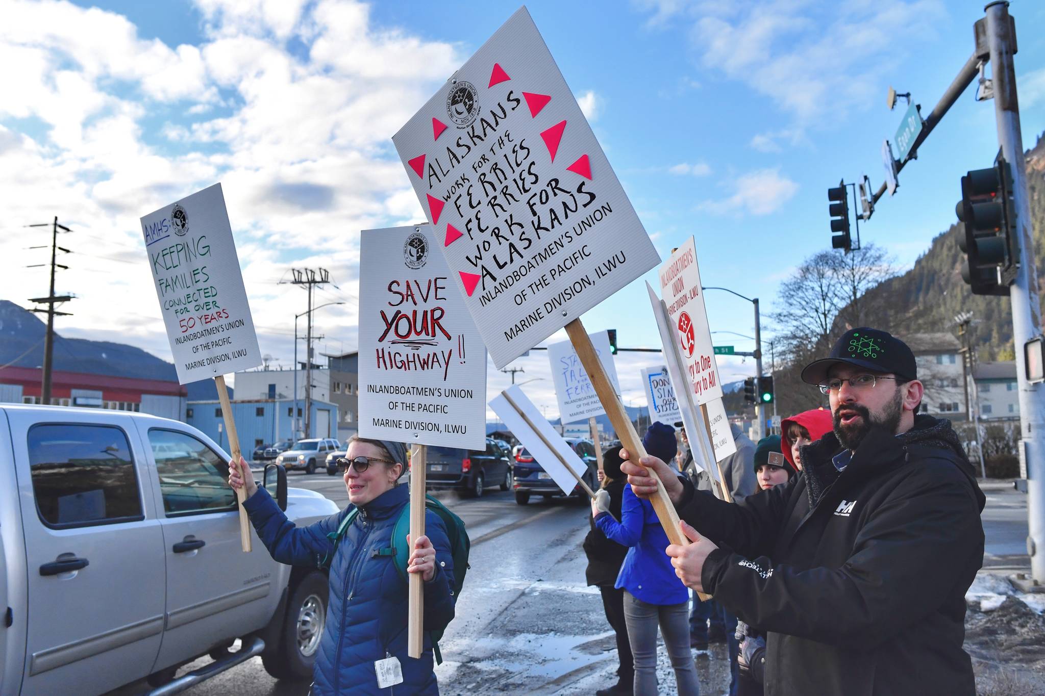 Sarah Eppon, left, and Earling Walli, right, join other ferry workers with the Inlandboatmen’s Union of the Pacific as they rally for support at 10th Street and Egan Drive on Friday, March 8, 2019. (Michael Penn | Juneau Empire)