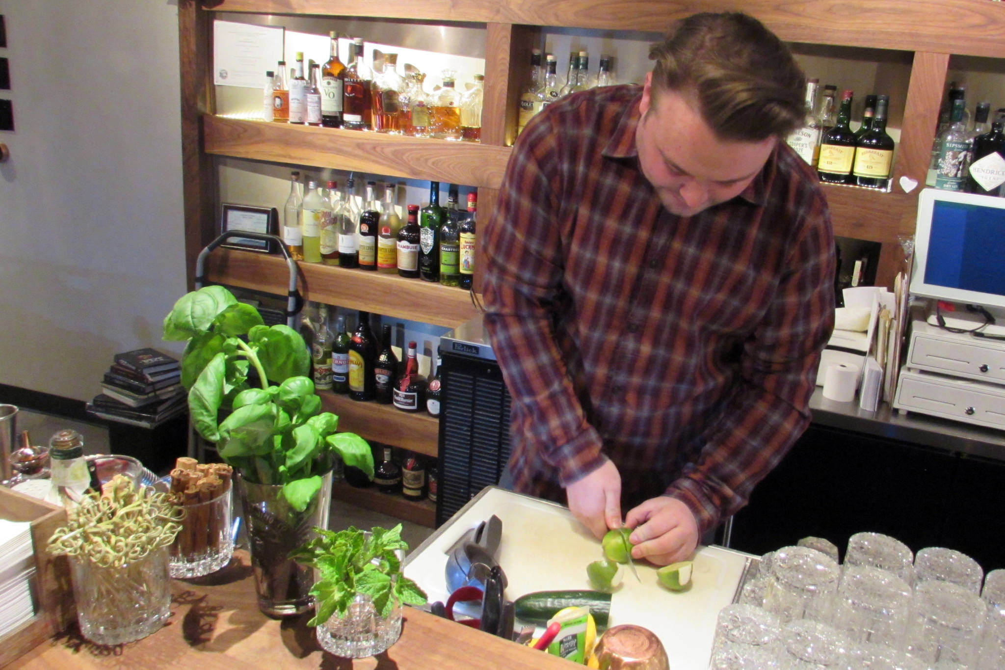 Jared Curé chops lime for a Garden Medley, a nonalcoholic mocktail, the Narrows Bar has on its menu for Sobriety Awareness Month, Tuesday, March 12. The drink was developed for a partnership with Recover Alaska. (Ben Hohenstatt | Juneau Empire)