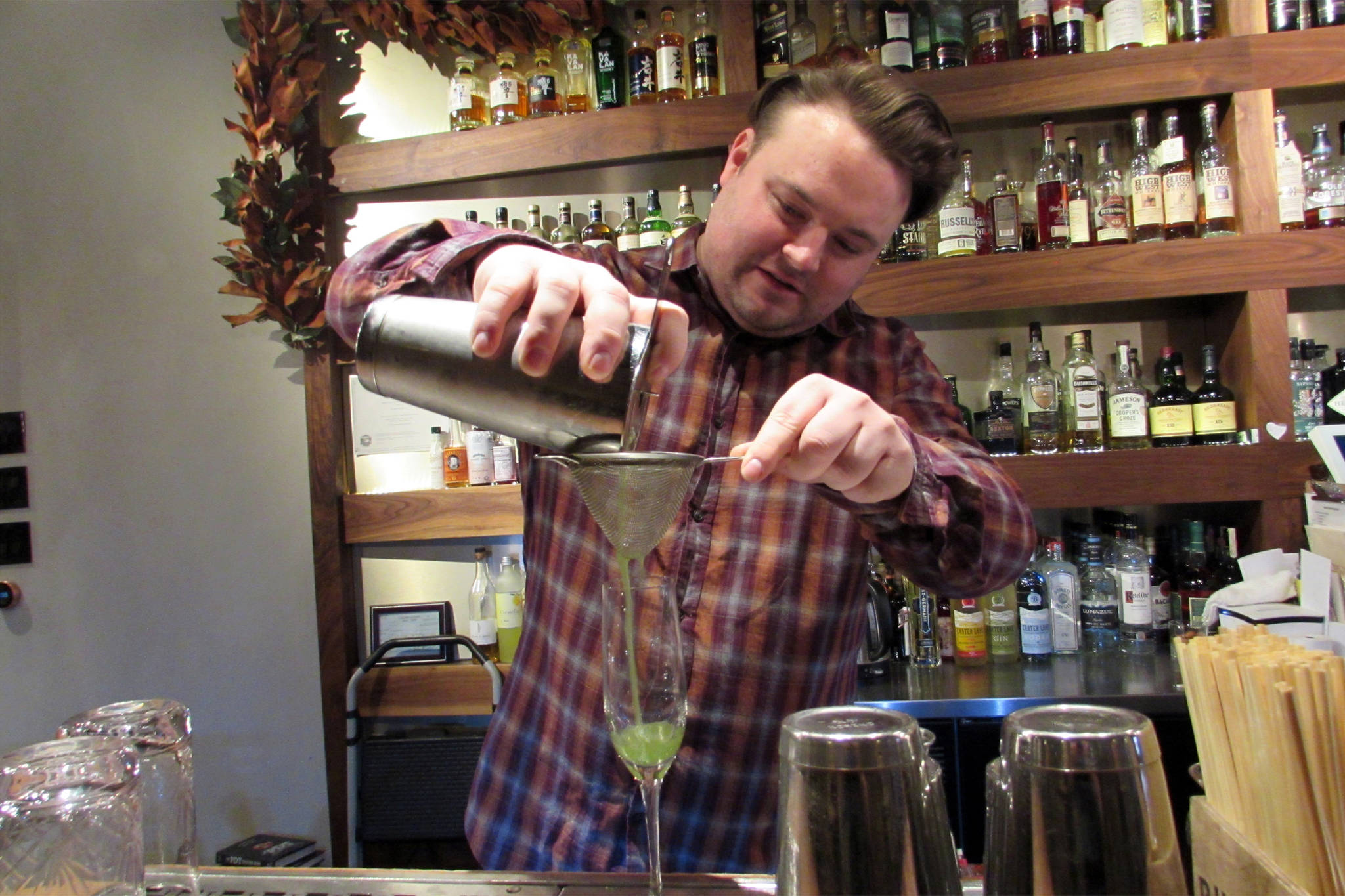 Jared Curé whips up a Garden Medley, a nonalcoholic mocktail, the Narrows Bar has on its menu for Sobriety Awareness Month, Tuesday, March 12. The drink was developed for a partnership with Recover Alaska. (Ben Hohenstatt | Juneau Empire)