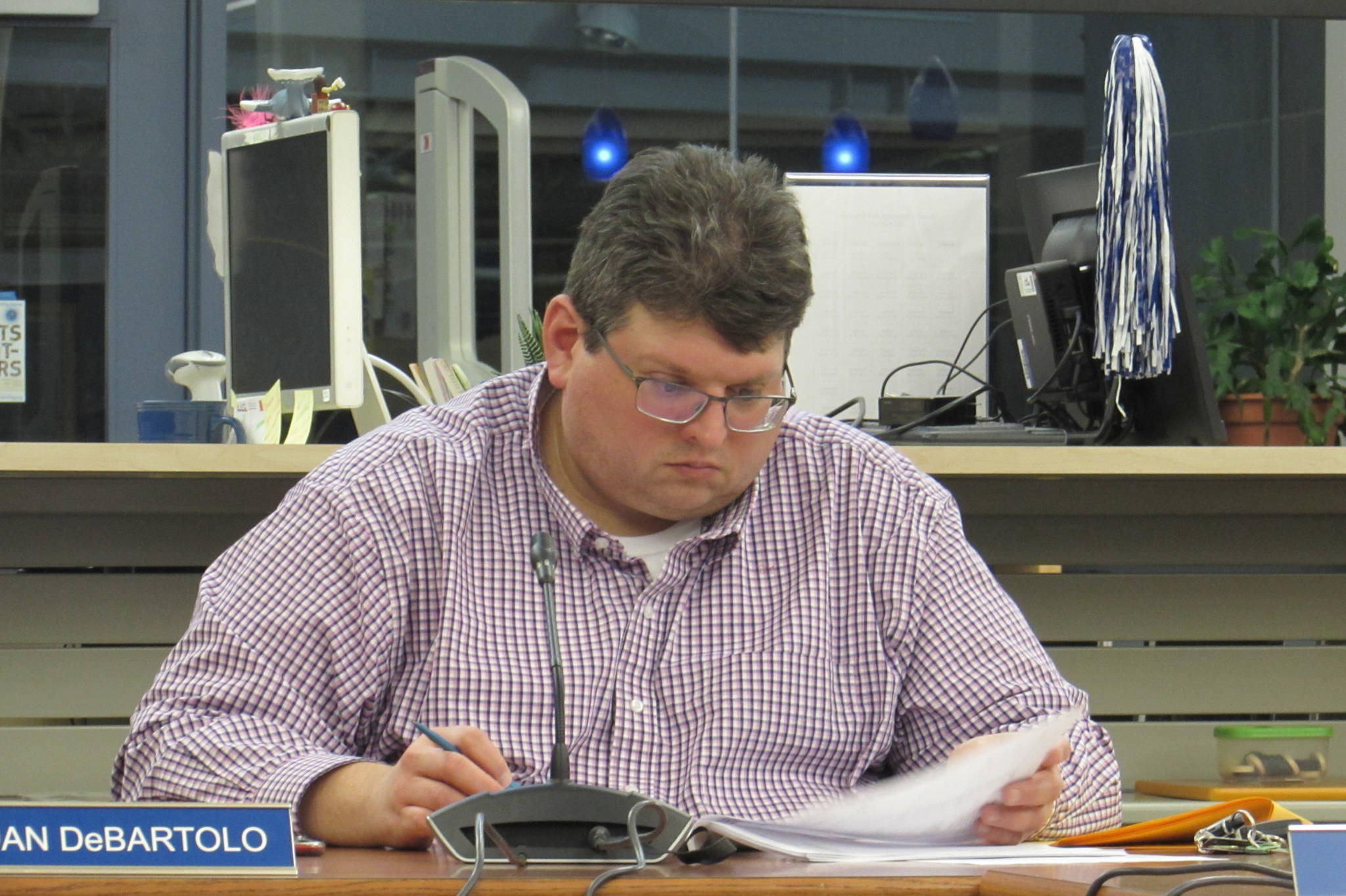Juneau School District School Board Vice President Dan DeBartolo looks at his meeting packet during budget discussions Tuesday, March 12, 2019. (Ben Hohenstatt | Juneau Empire)