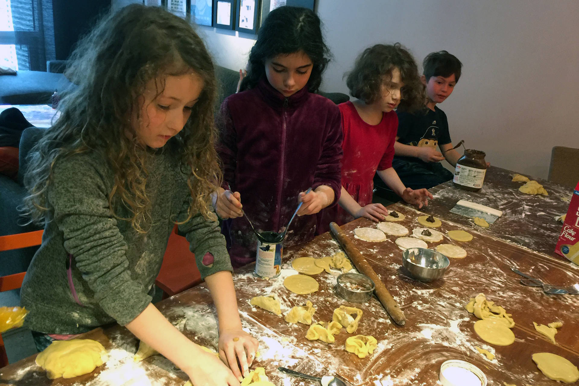 Members of local Jewish youth group Beit Sefer Sunna Schane, Gracie Snyder, Sadie Curtis and Isaac Kirsch make Hamantaschen, a traditional holiday treat, ahead of Purim. (Courtesy Photo | Congregation Sukkat Shalom)