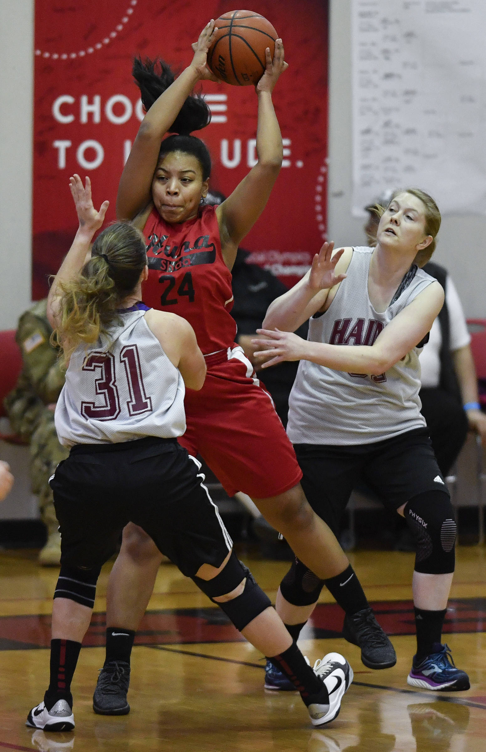 Hoonah’s Zhane White comes up with a rebound between Haines’ Rachel Brittenham, left, and Sabrina Stickler in the women’s bracket game at the Gold Medal Basketball Tournament on Thursday, March 21, 2019. (Michael Penn | Juneau Empire)