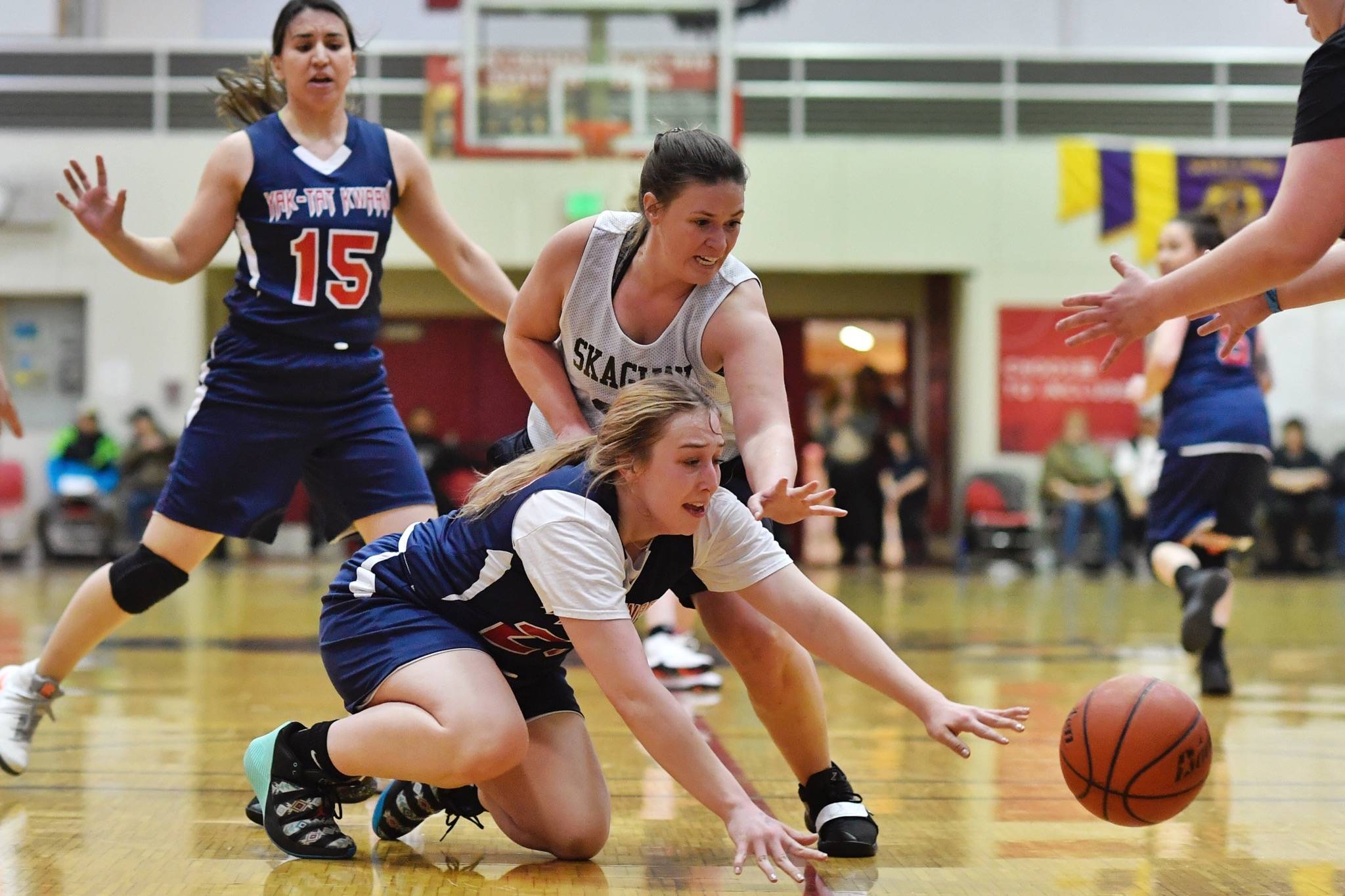 Yakutat’s Janie Jensen, bottom, and Skagway’s Tiffanie Ames dive for a loose ball during their women’s bracket game at the Lions Club’s Gold Medal Basketball Tournament on Thursday, March 21, 2019. (Michael Penn | Juneau Empire)