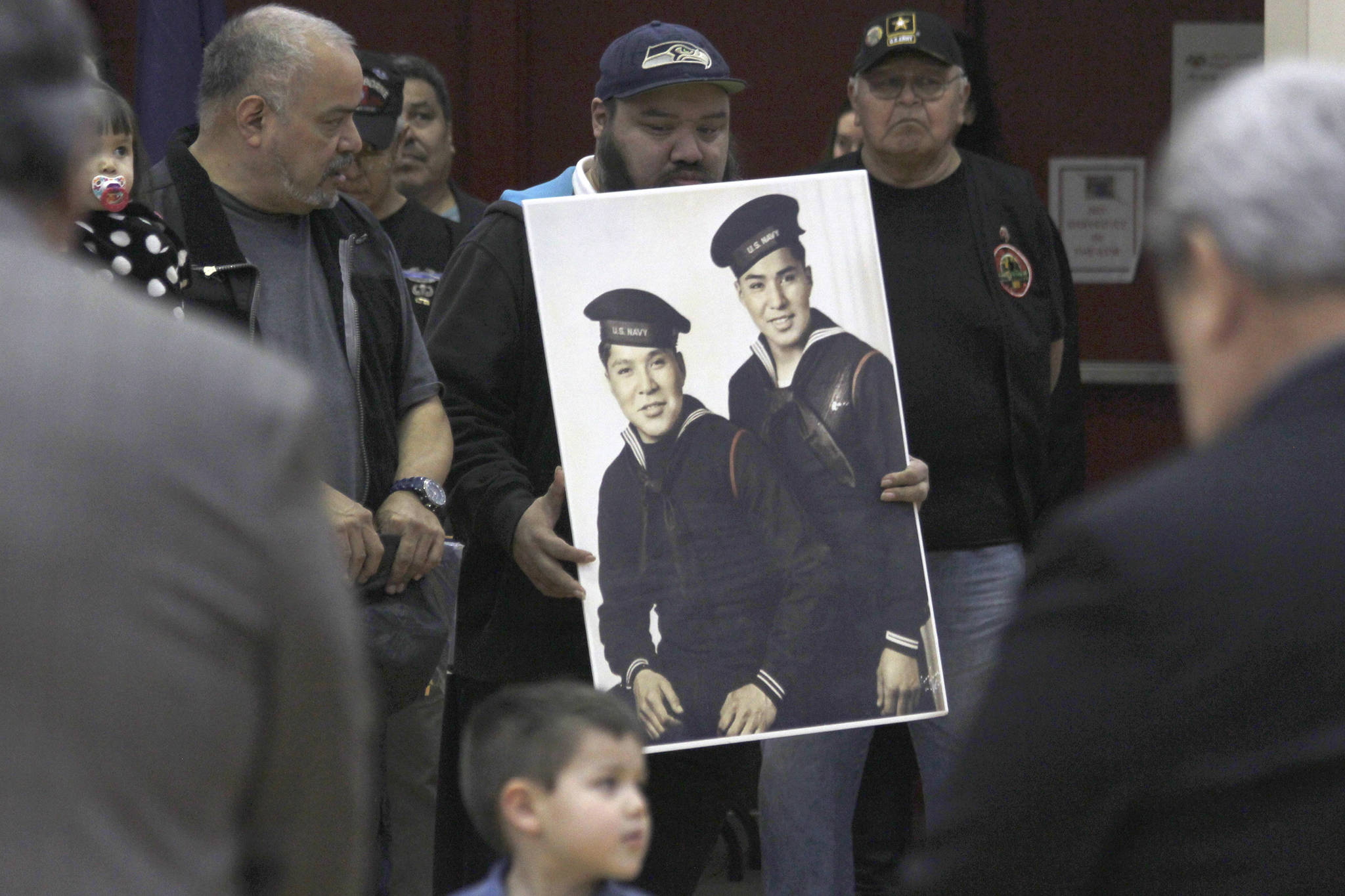 Family members of brothers Mark and Harvey Jacobs hold a picture of the brothers during a ceremony honoring Tlingit code talkers on Monday, March 18, 2019. (Alex McCarthy | Juneau Empire)