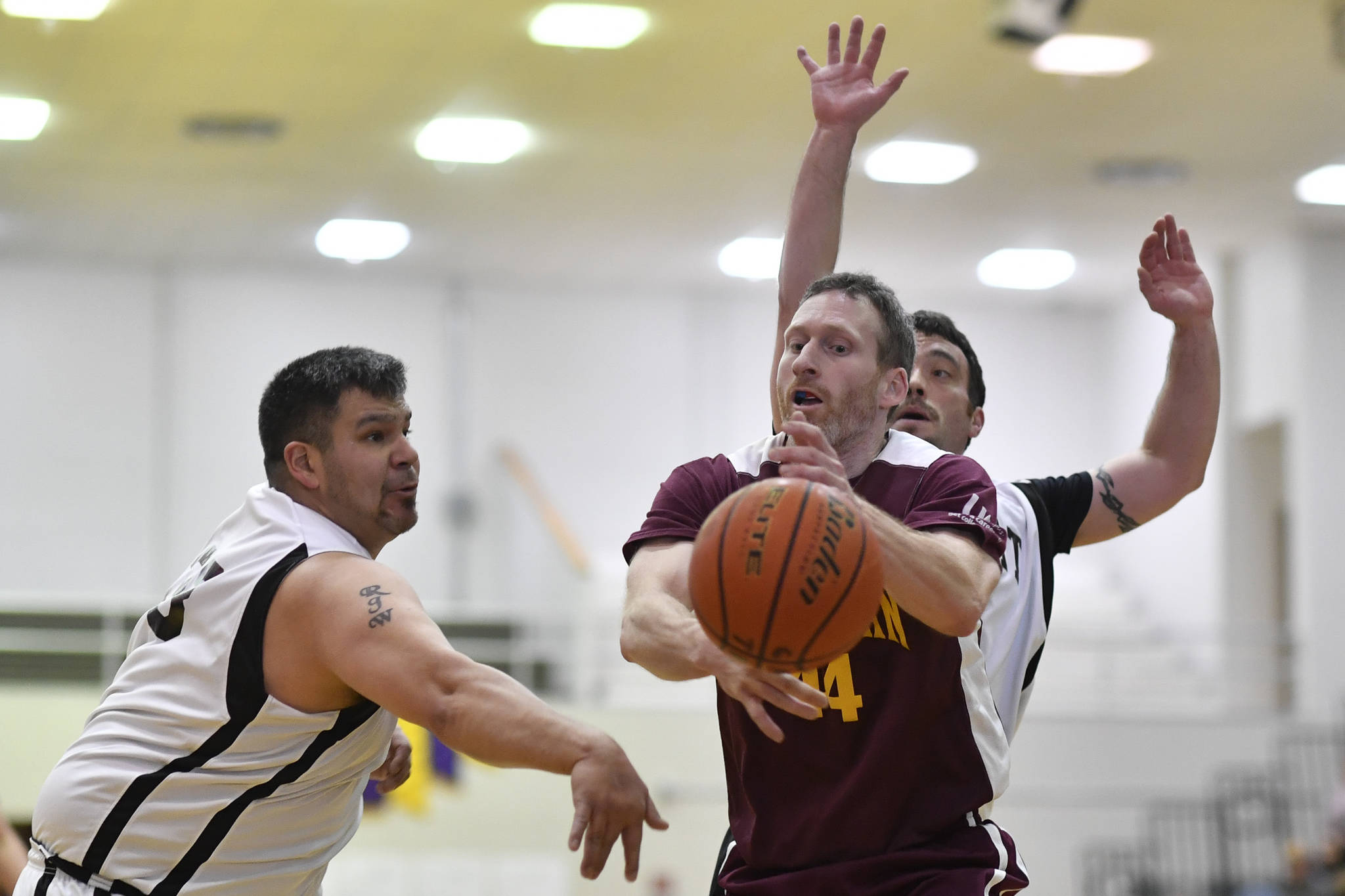 Klukwan’s Andrew Friske, center, has the ball batted away by Yakutat’s Ralph Wolfe, left, at the Juneau Lions Club 73rd Annual Gold Medal Basketball Tournament at Juneau-Douglas High School: Yadaa.at Kalé on Tuesday, March 19, 2019. Klukwan won 94-61. (Michael Penn | Juneau Empire)
