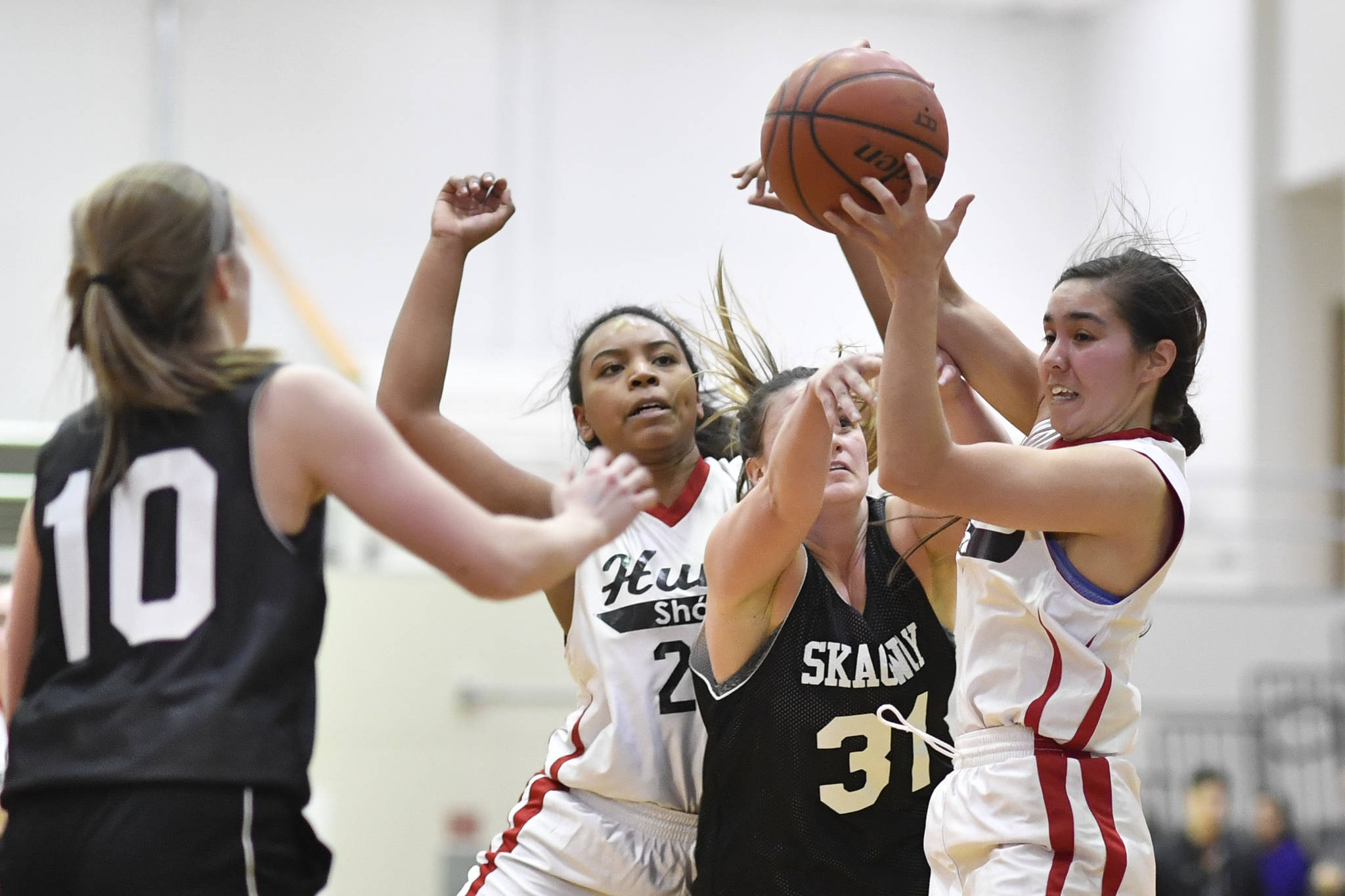 Skagway’s Tiffanie Ames, center, has the ball stripped away by Hoonah’s Melissa Fisher, right, and Zhane White at the Juneau Lions Club 73rd Annual Gold Medal Basketball Tournament at Juneau-Douglas High School: Yadaa.at Kalé on Tuesday, March 19, 2019. Skagway won 80-42. (Michael Penn | Juneau Empire)