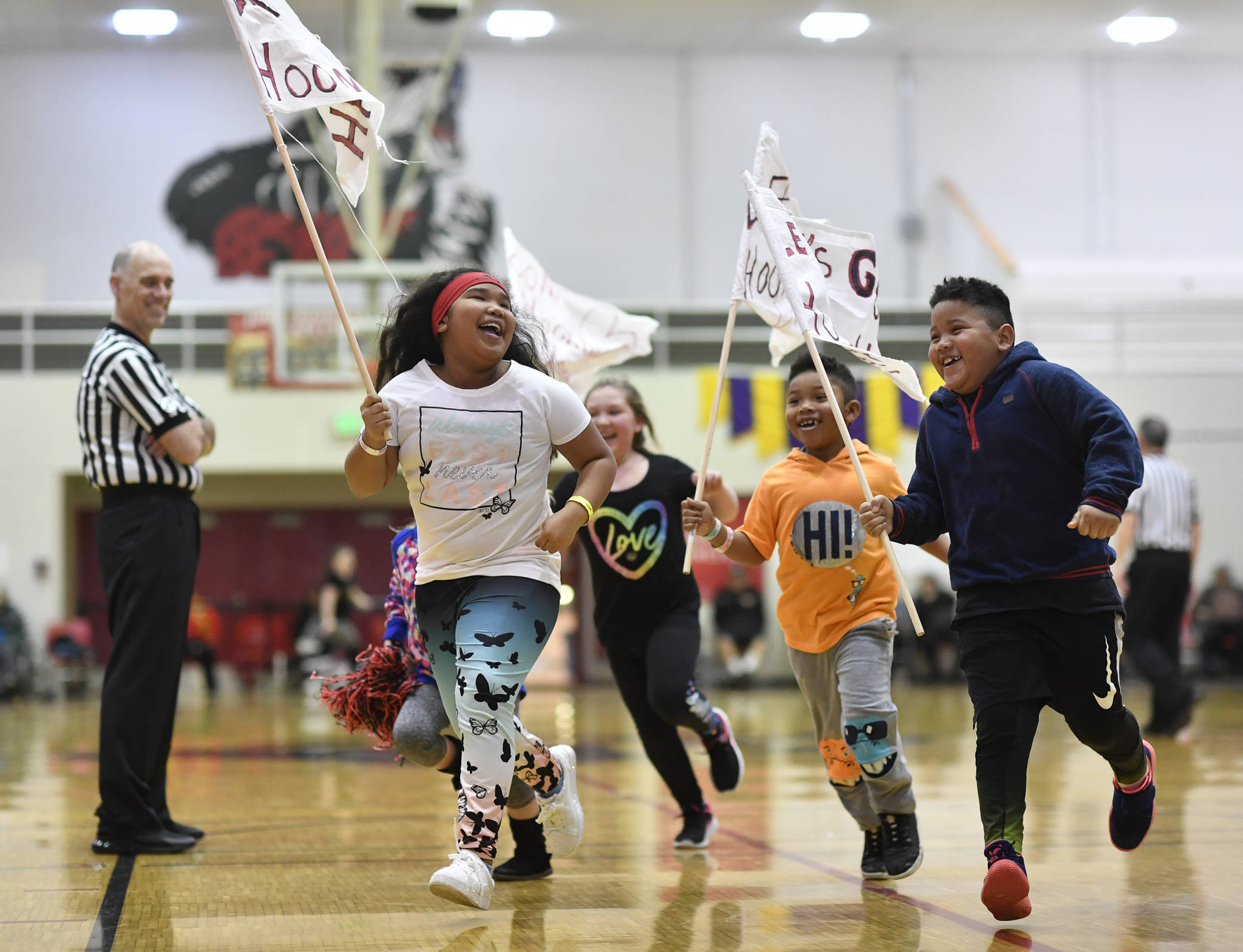 Children with Hoonah flags parade around the gymnasium during a break in the women’s game against Skagway at the Juneau Lions Club 73rd Annual Gold Medal Basketball Tournament at Juneau-Douglas High School: Yadaa.at Kalé on Tuesday, March 19, 2019. Skagway won 80-42. (Michael Penn | Juneau Empire)