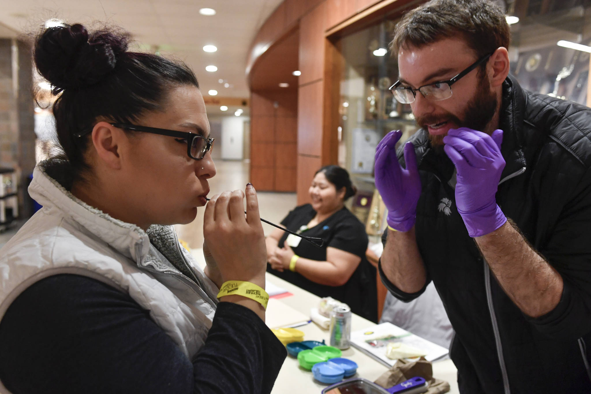 Dr. Jordan White, right, a dentist with the Southeast Alaska Regional Health Consortium, helps fit a mouth guard for Barbara Jean Johnson, of Yakutat, at the Juneau Lions Club 73rd Annual Gold Medal Basketball Tournament at Juneau-Douglas High School: Yadaa.at Kalé on Tuesday, March 19, 2019. (Michael Penn | Juneau Empire)