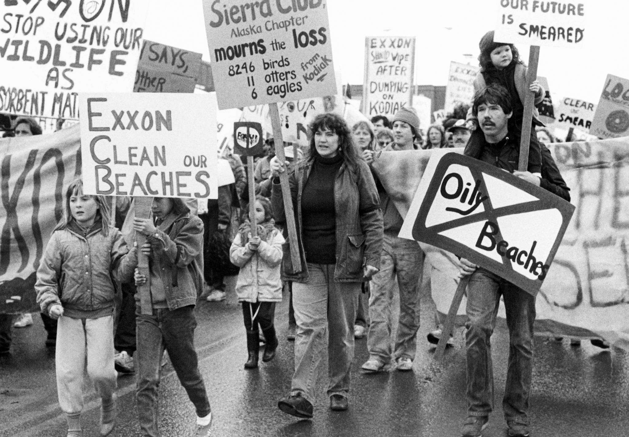 In this May 27, 1989 photo, people carry signs to protest the Exxon oil spill in Anchorage, Alaska. It’s been 30 years since the disaster, at the time the largest oil spill in U.S. history. (Marion Stirrup | Associated Press File)