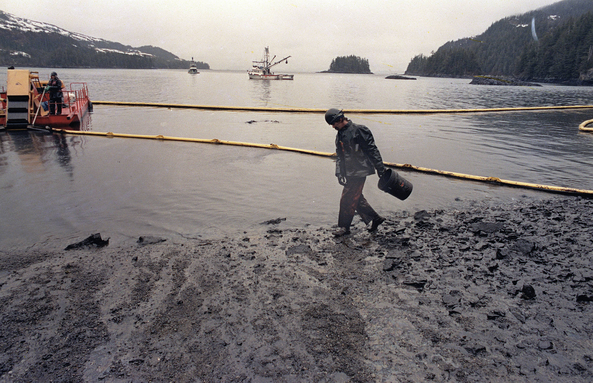 In this April 17, 1989 photo, a worker makes his way across the polluted shore of Block Island, Alaska, as efforts are underway to test techniques to clean up the oil spill of the tanker Exxon Valdez in Prince William Sound. The Exxon Valdez tanker struck Alaska’s Bligh Reef on March 24, 1989, while bound for California. It spilled about 11 million gallons of crude oil, which storms and currents smeared across about 1,300 miles of shoreline. (John Gaps III | Associated Press File)