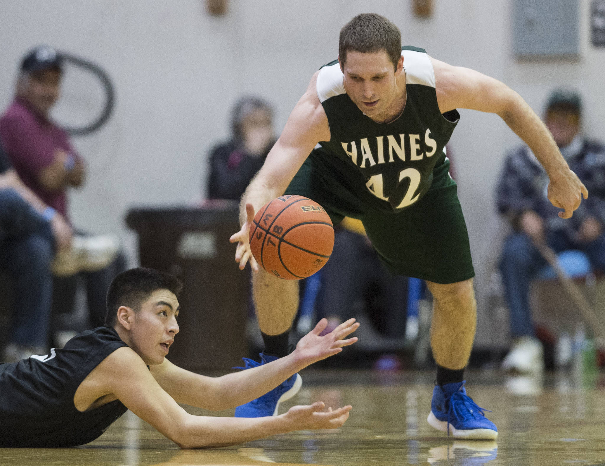 Haines’ Kyle Fossman, right, and Hydaburg’s Roger Trout chase a loose ball during their B bracket game at the Juneau Lions Club 73rd Annual Gold Medal Basketball Tournament at Juneau-Douglas High School: Yadaa.at Kalé on Thursday, March 21, 2019. Haines won 78-52. (Michael Penn | Juneau Empire)