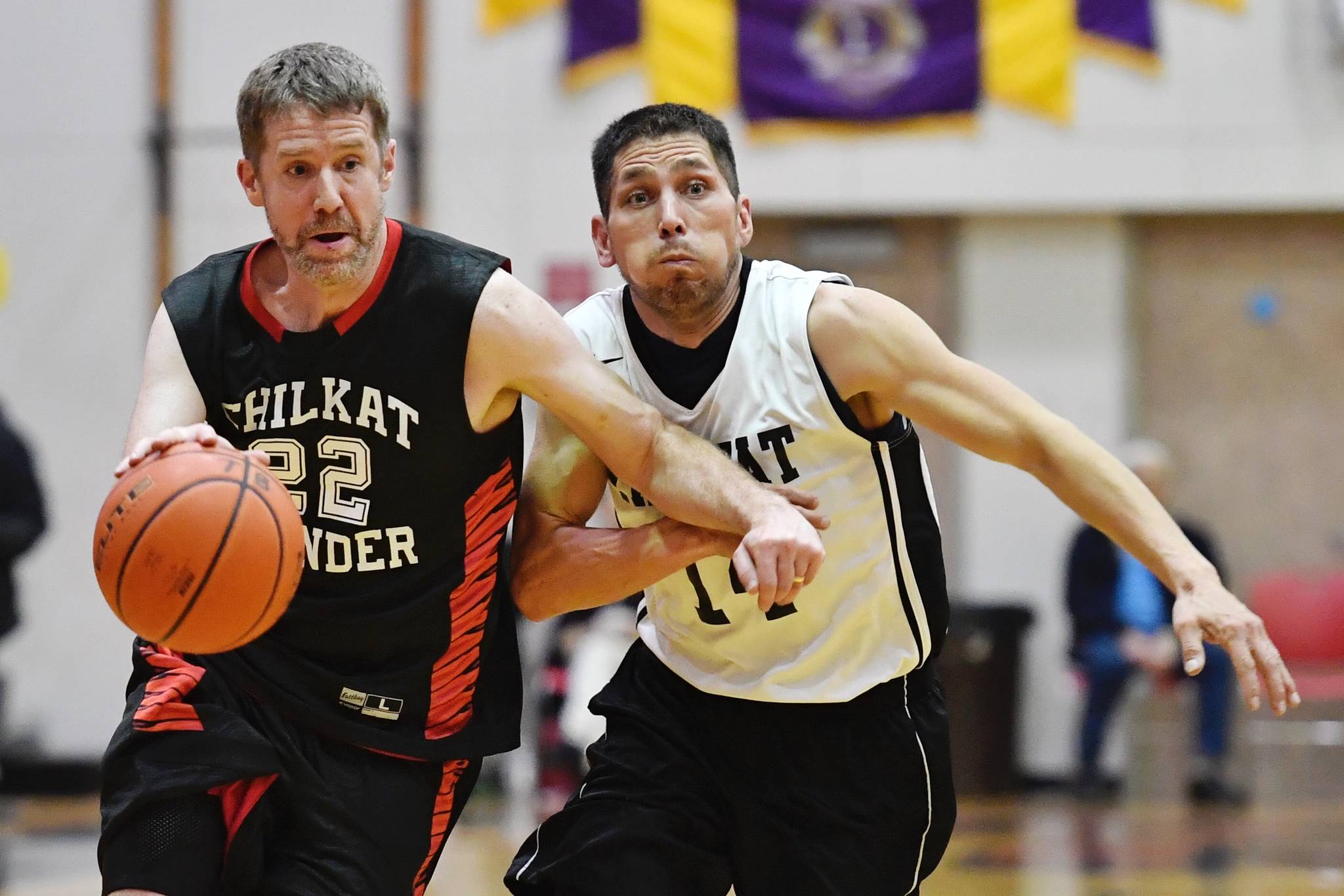 Klukwan’s Dave Buss, left, drives against Yakutat’s Ralph Johnson during their masters bracket game at the Gold Medal Basketball Tournament on Friday, March 22, 2019. (Michael Penn | Juneau Empire)