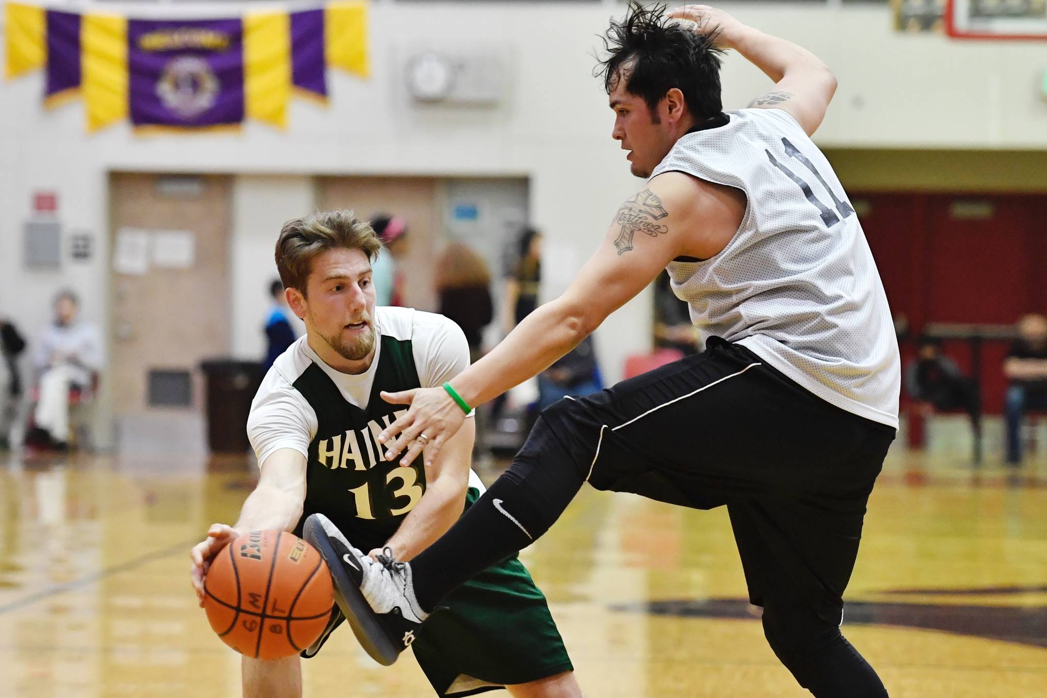 Metlakatla’s Shane Martinez, right, gets a foot on the ball against Haines’ Orion Farley during their B bracket game at the Gold Medal Basketball Tournament on Friday, March 22, 2019. (Michael Penn | Juneau Empire)