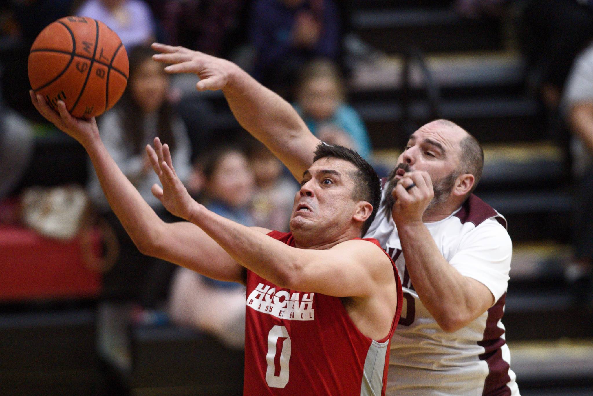 Hoonah’s Anthony Lindoff, left, lays the ball up against Klukwan’s Stuart DeWitt in their C bracket game at the Gold Medal Basketball Tournament on Friday, March 22, 2019. (Michael Penn | Juneau Empire)