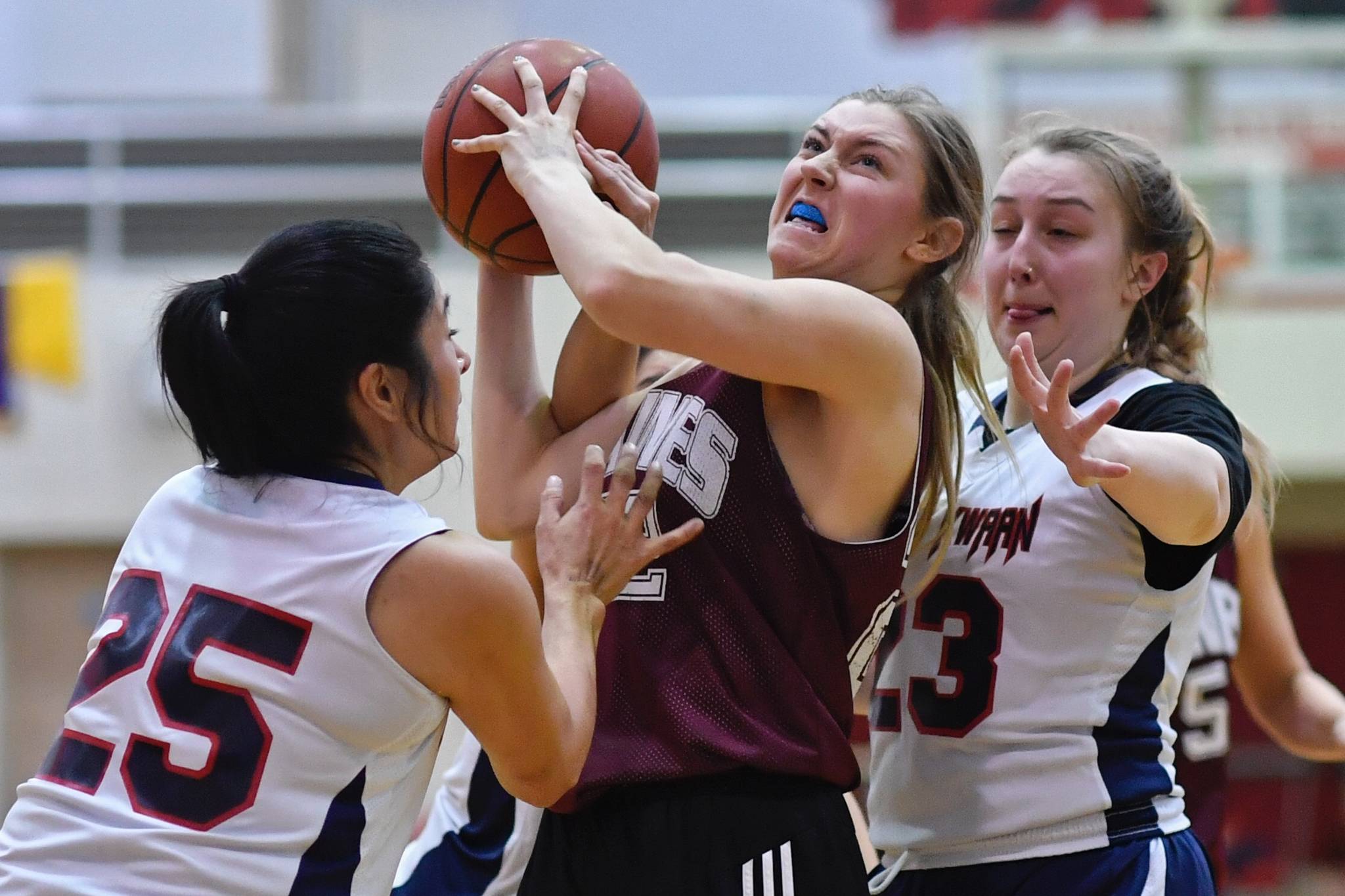 Haines’ Liz Segars, center, powers her way between Yakutat ‘s Violet Slatterly, left, and Janie Jensen at the Gold Medal Basketball Tournament on Friday, March 22, 2019. (Michael Penn | Juneau Empire)