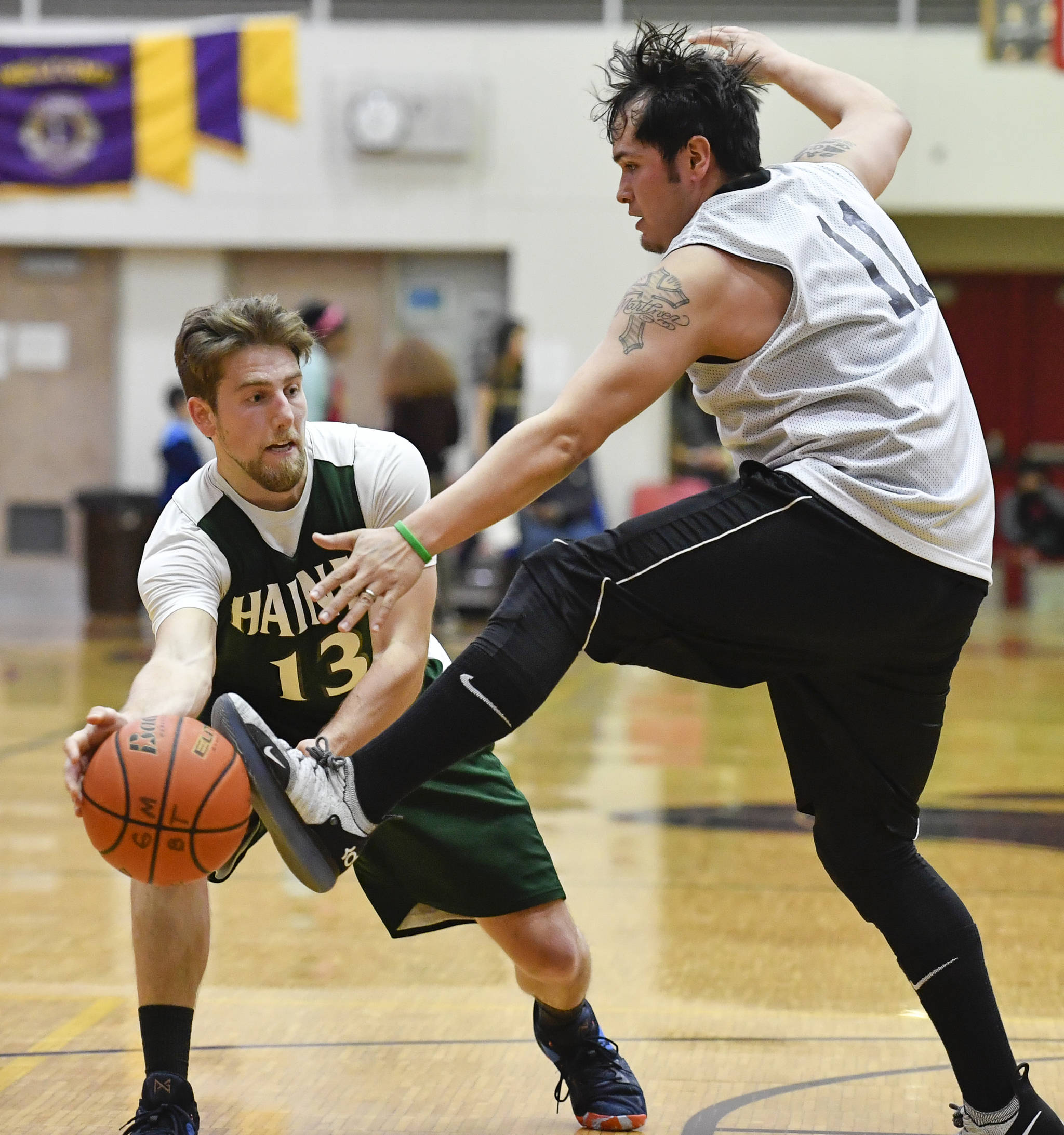 Metlakatla’s Shane Martinez, right, gets a foot on the ball against Haines’ Orion Farley during their B bracket game at the Juneau Lions Club 73rd Annual Gold Medal Basketball Tournament at Juneau-Douglas High School on Friday, March 22, 2019. (Michael Penn | Juneau Empire)