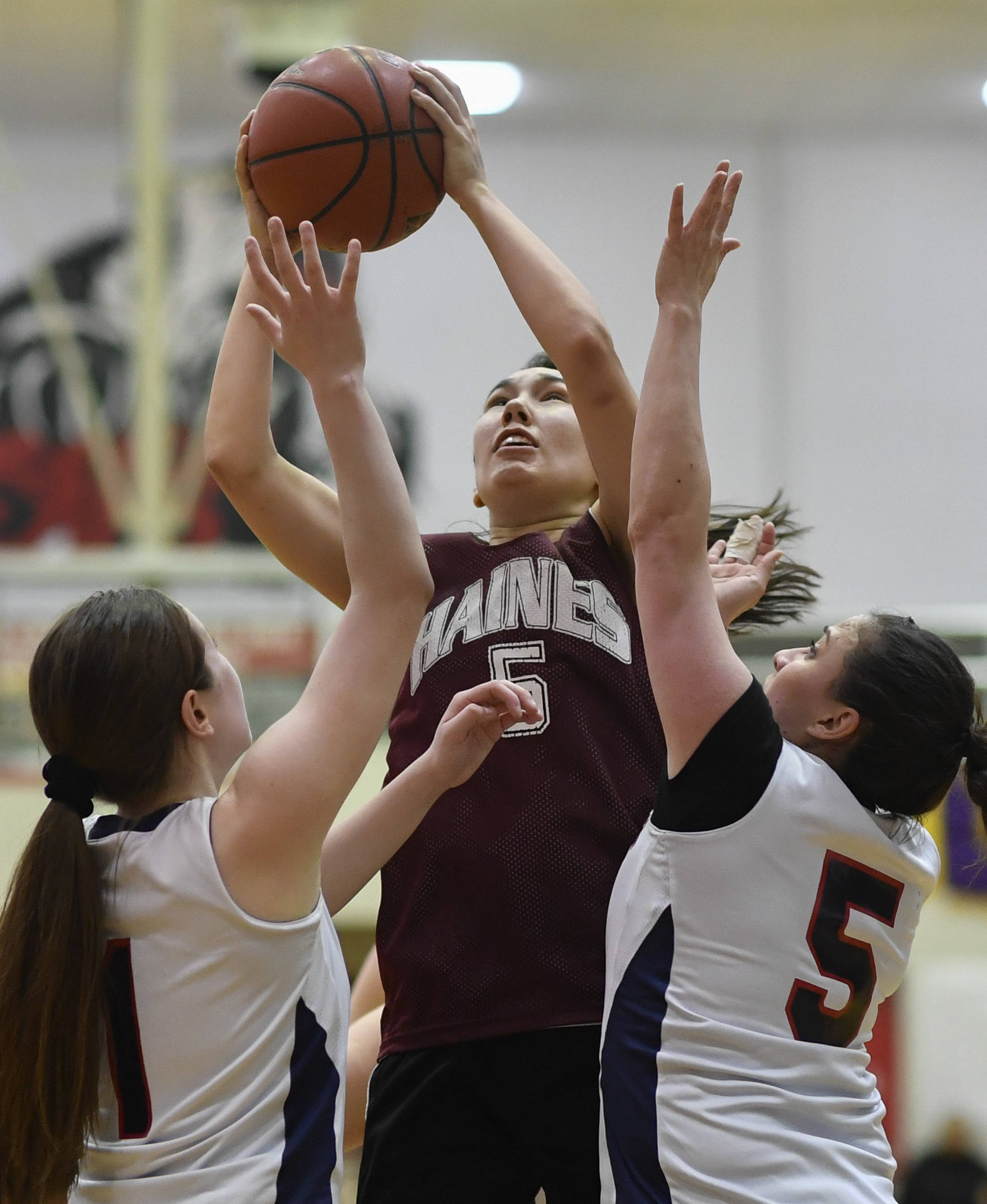 Haines’ Fran Daly, center, shoots over Yakutat’s Shaye Jensen, left, and Kim Buller during their women’s bracket game at the Juneau Lions Club 73rd Annual Gold Medal Basketball Tournament at Juneau-Douglas High School on Friday, March 22, 2019. Haines won 64-48. (Michael Penn | Juneau Empire)