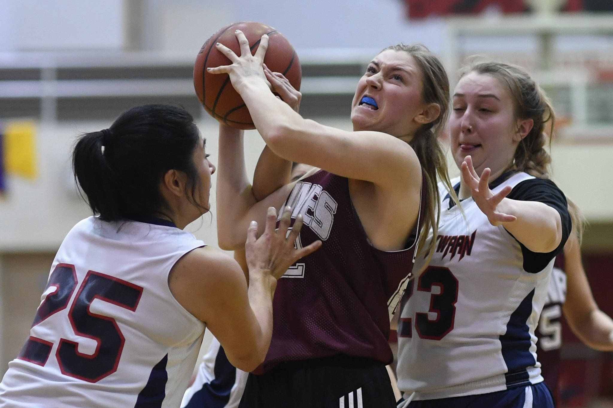Haines’ Liz Segars, center, powers her way between Yakutat’s Violet Slatterly, left, and Janie Jensen during their women’s bracket game at the Juneau Lions Club 73rd Annual Gold Medal Basketball Tournament at Juneau-Douglas High School on Friday, March 22, 2019. Haines won 64-48. (Michael Penn | Juneau Empire)