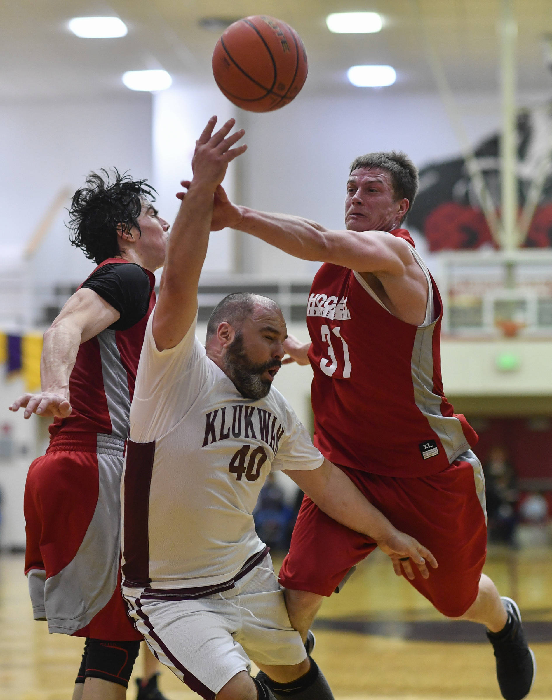 Klukwan’s Stuart DeWitt, center, attempts to score on Hoonah’s Donald Dybdahl, left, and Greg Strout during their C bracket game at the Juneau Lions Club 73rd Annual Gold Medal Basketball Tournament at Juneau-Douglas High School on Friday, March 22, 2019. Klukwan won 88-67. (Michael Penn | Juneau Empire)
