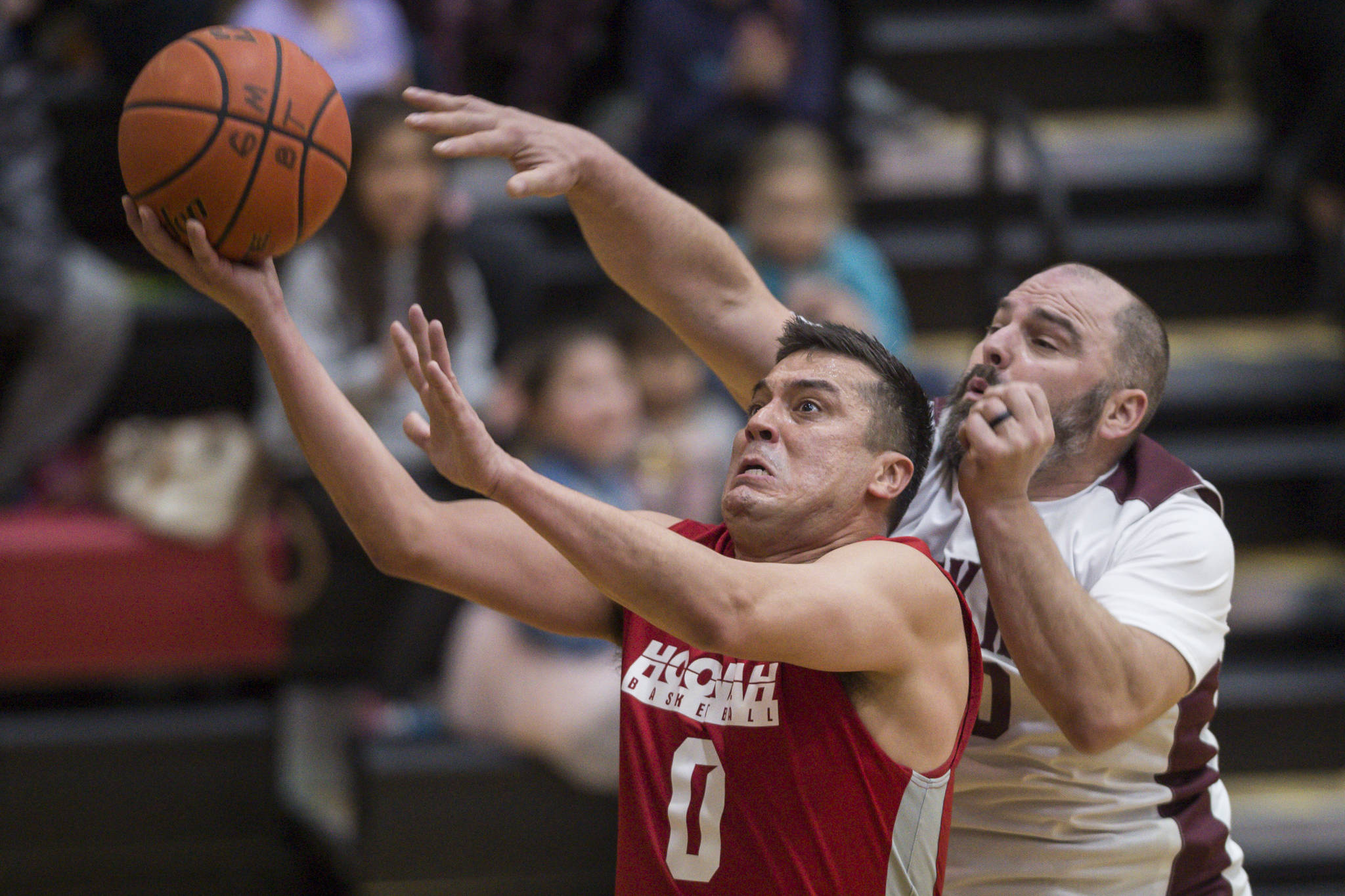 Hoonah’s Anthony Lindoff, left, scores in front of Klukwan’s Stuart DeWitt during their C bracket game at the Juneau Lions Club 73rd Annual Gold Medal Basketball Tournament at Juneau-Douglas High School on Friday, March 22, 2019. Klukwan won 88-67. (Michael Penn | Juneau Empire)
