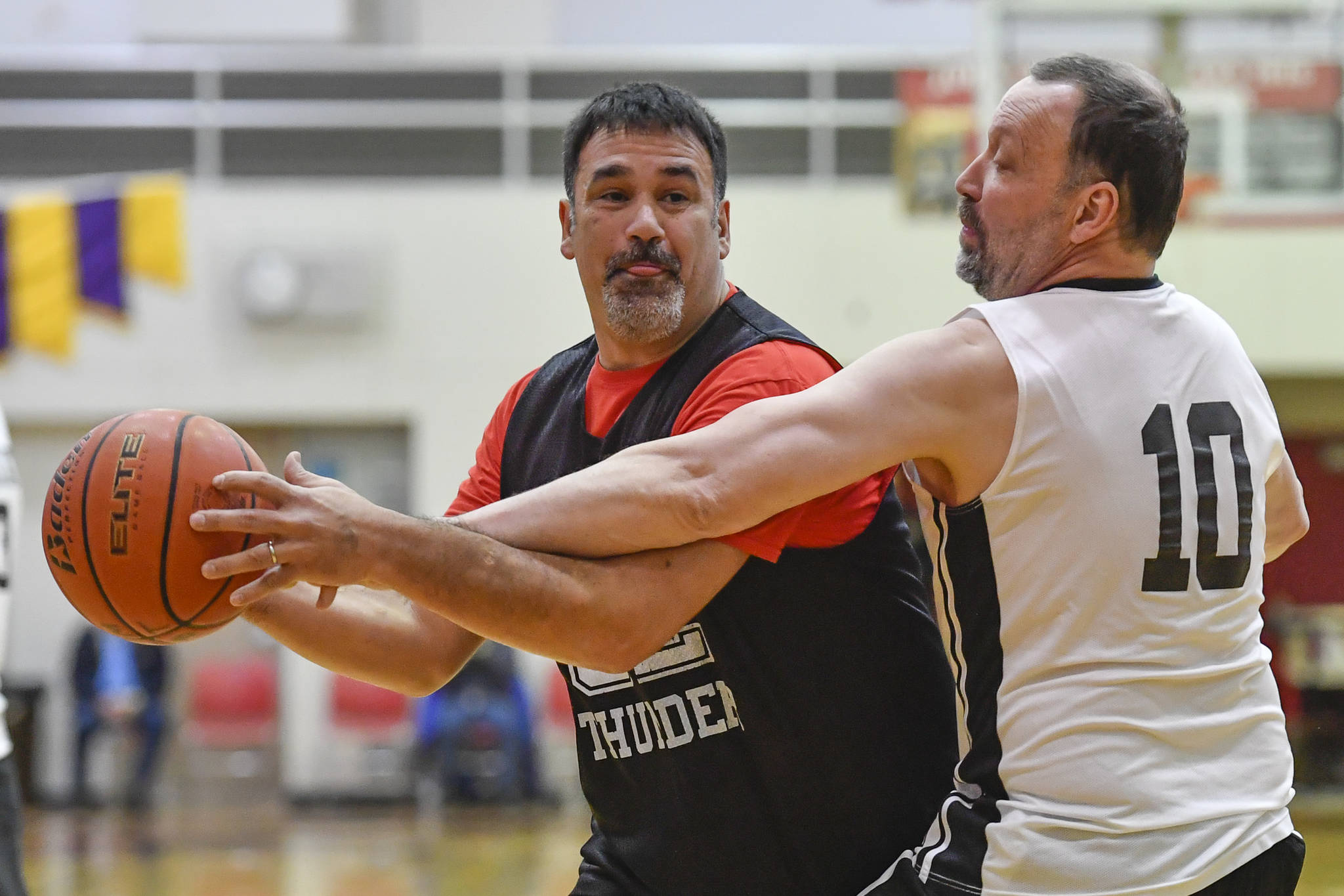 Klukwan’s Neil Erickson, left, is closely guarded by Yakutat’s Greg Indreland during their Masters bracket game at the Juneau Lions Club 73rd Annual Gold Medal Basketball Tournament at Juneau-Douglas High School on Friday, March 22, 2019. Klukwan won 63-58. (Michael Penn | Juneau Empire)