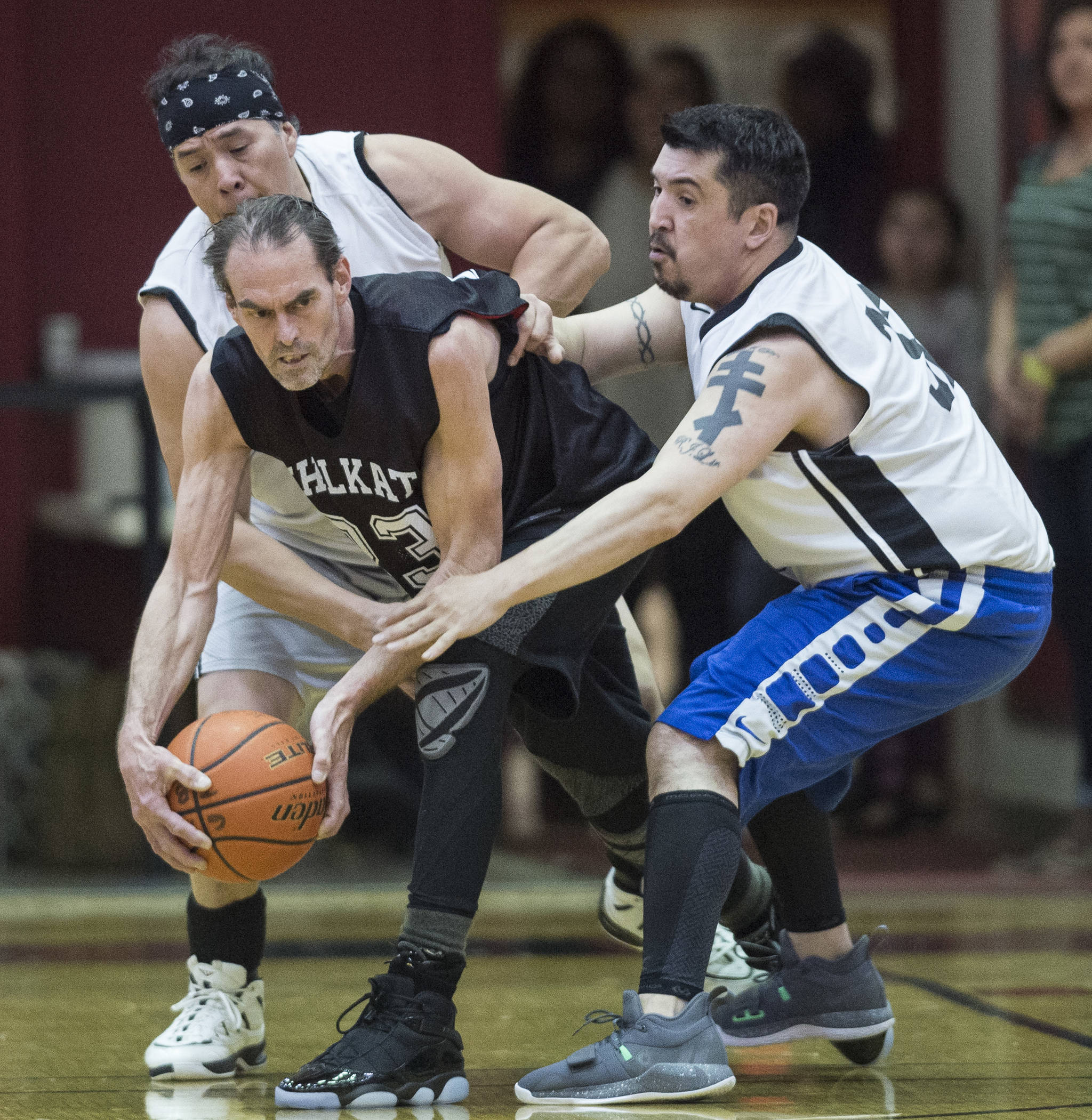 Klukwan’s Mike Bott, center, is pressured by Yakutat’s Sam Demmert, left, and Bob Lekanof during their Masters bracket game at the Juneau Lions Club 73rd Annual Gold Medal Basketball Tournament at Juneau-Douglas High School on Friday, March 22, 2019. Klukwan won 63-58. (Michael Penn | Juneau Empire)