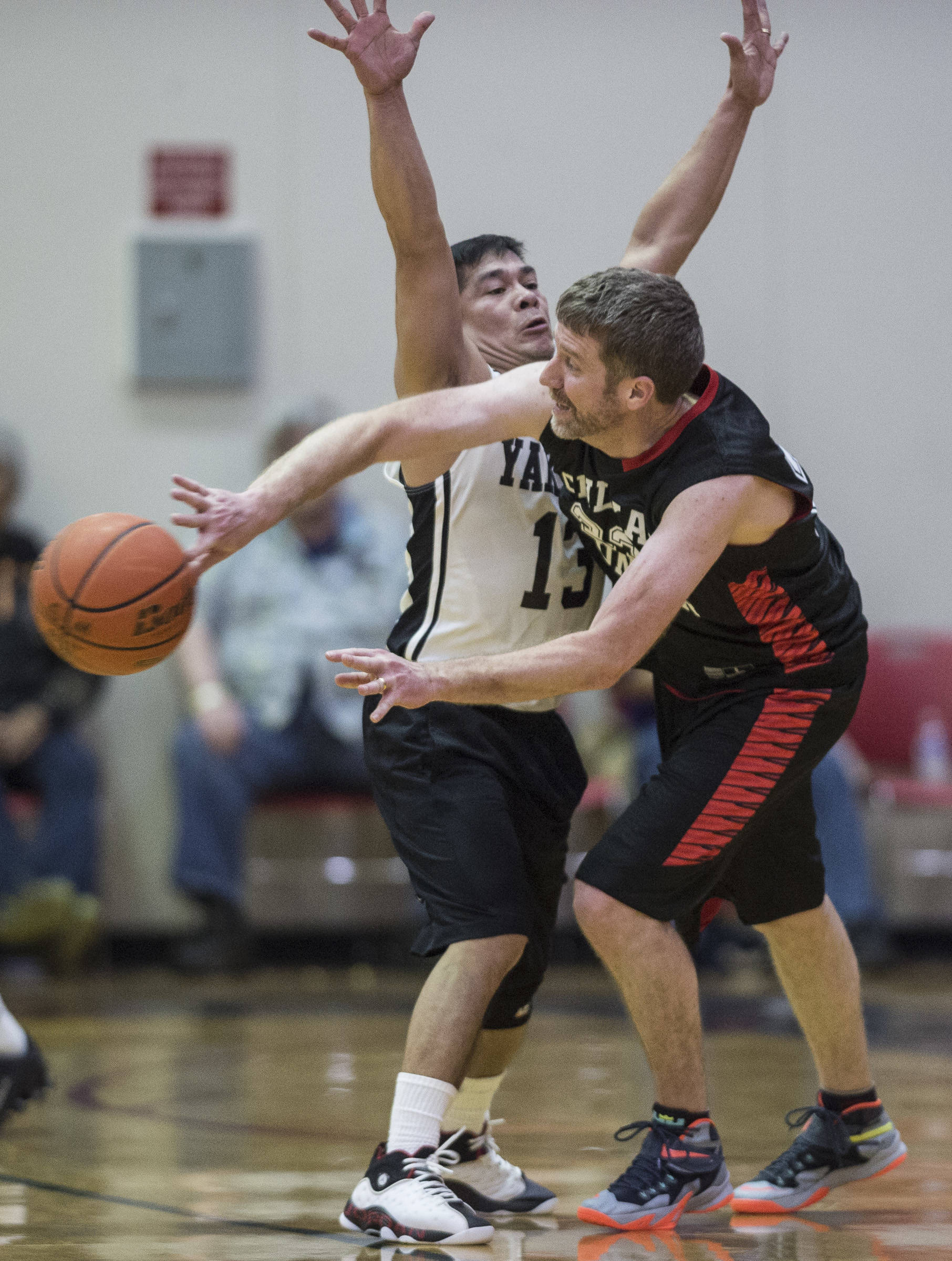 Haines’ Dave Buss, right, passes around Yakutat’s Jerry Riddington during their Masters bracket game at the Juneau Lions Club 73rd Annual Gold Medal Basketball Tournament at Juneau-Douglas High School on Friday, March 22, 2019. Klukwan won 63-58. (Michael Penn | Juneau Empire)
