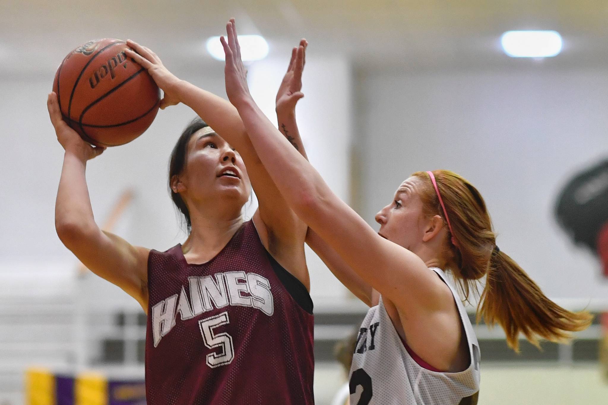 Haines’ Fran Daly, left, scores on Skagway’s Jesse Ellis in the women’s final at the Gold Medal Basketball Tournament on Saturday, March 23, 2019. (Michael Penn | Juneau Empire)