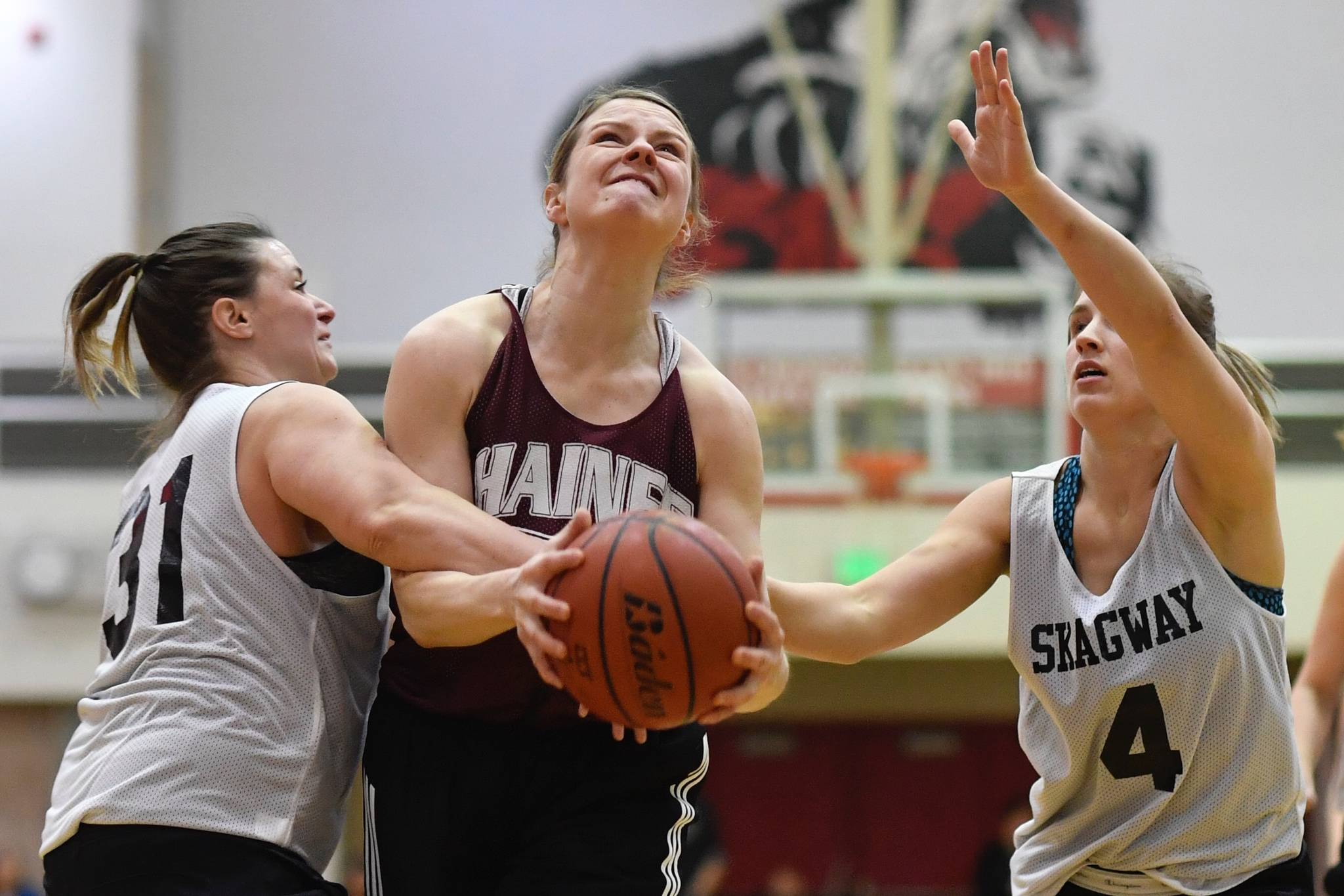 Haines’ Alisa Beske , center, is fouled by Skagway’s Tiffanie Ames, left, in the women’s final at the Gold Medal Basketball Tournament on Saturday, March 23, 2019. (Michael Penn | Juneau Empire)