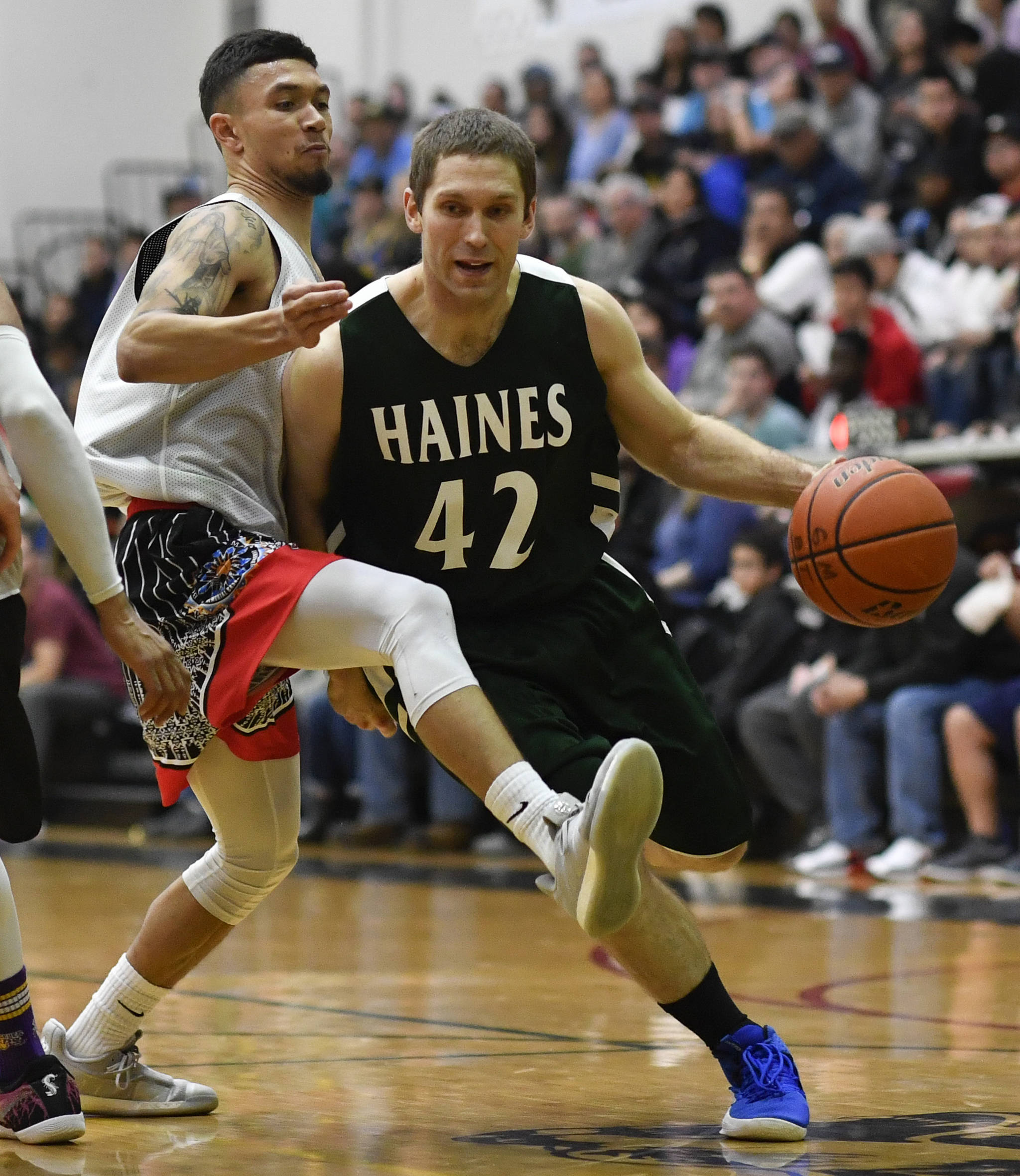 Angoon’s Aquino Brinson attempts to stay in front of Haines’ Kyle Fossman in the B final at the Gold Medal Basketball Tournament on Saturday, March 23, 2019. Haines won 88-80. (Michael Penn | Juneau Empire)