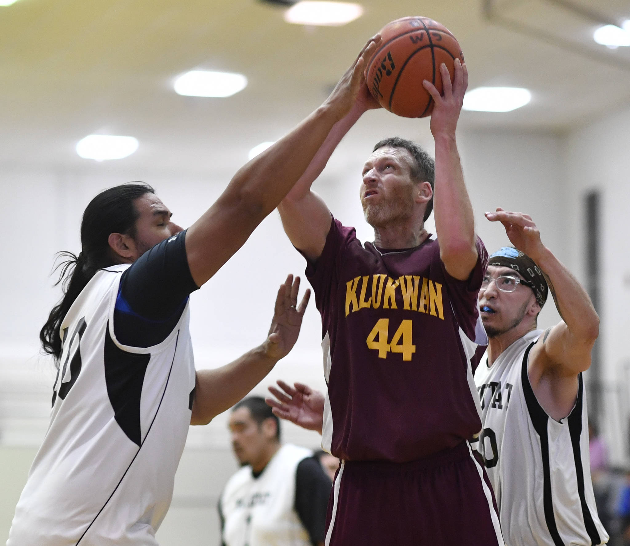 Klukwan’s Andrew Friske, center, shoots against Yakutat’s Derek James, left, at the Juneau Lions Club 73rd Annual Gold Medal Basketball Tournament at Juneau-Douglas High School: Yadaa.at Kalé on Tuesday, March 19, 2019. Friske was the recipient of the Dr. Walter A. Soboleff Award for his outstanding community involvement among other traits. (Michael Penn | Juneau Empire File)