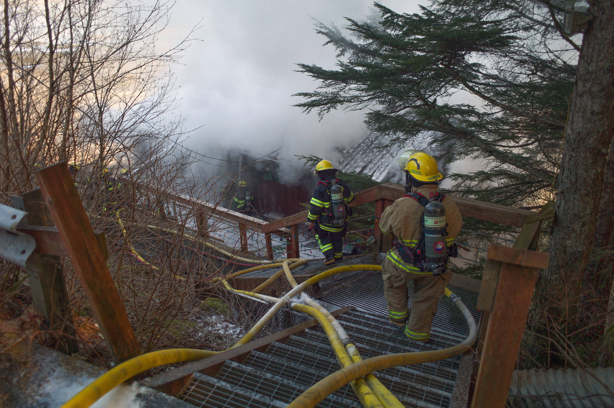 Firefighters work the scene of a house fire on North Douglas Highway on Thursday, March 28, 2019. (Michael Penn | Juneau Empire)