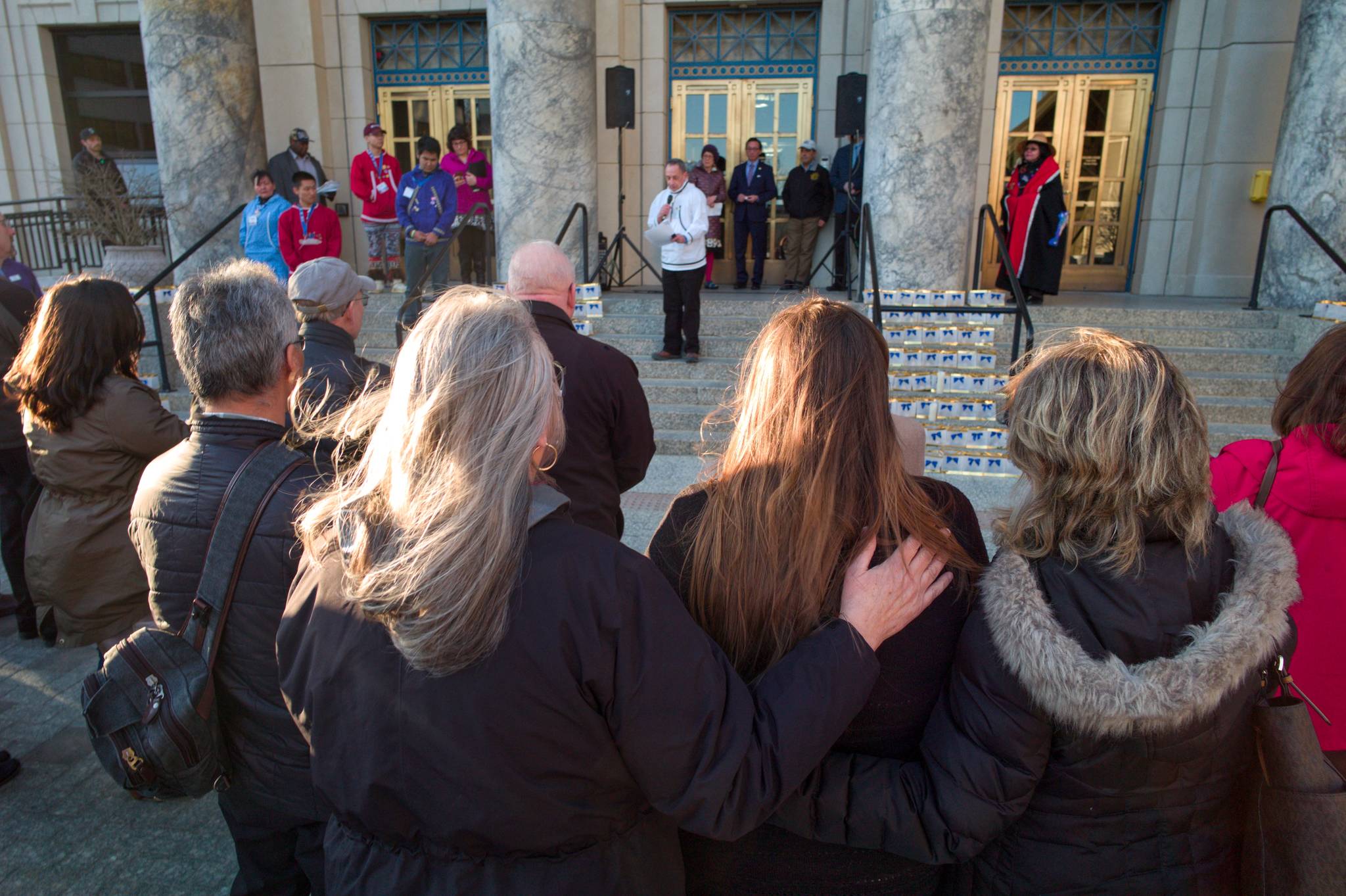 Juneau residents listen to James Biela, lead field advocate the Alaska Chapter of the American Foundation for Suicide Prevention, as he speaks at a candlelight vigil to raise awareness at the Capitol on Tuesday, March 26, 2019. (Michael Penn | Juneau Empire)