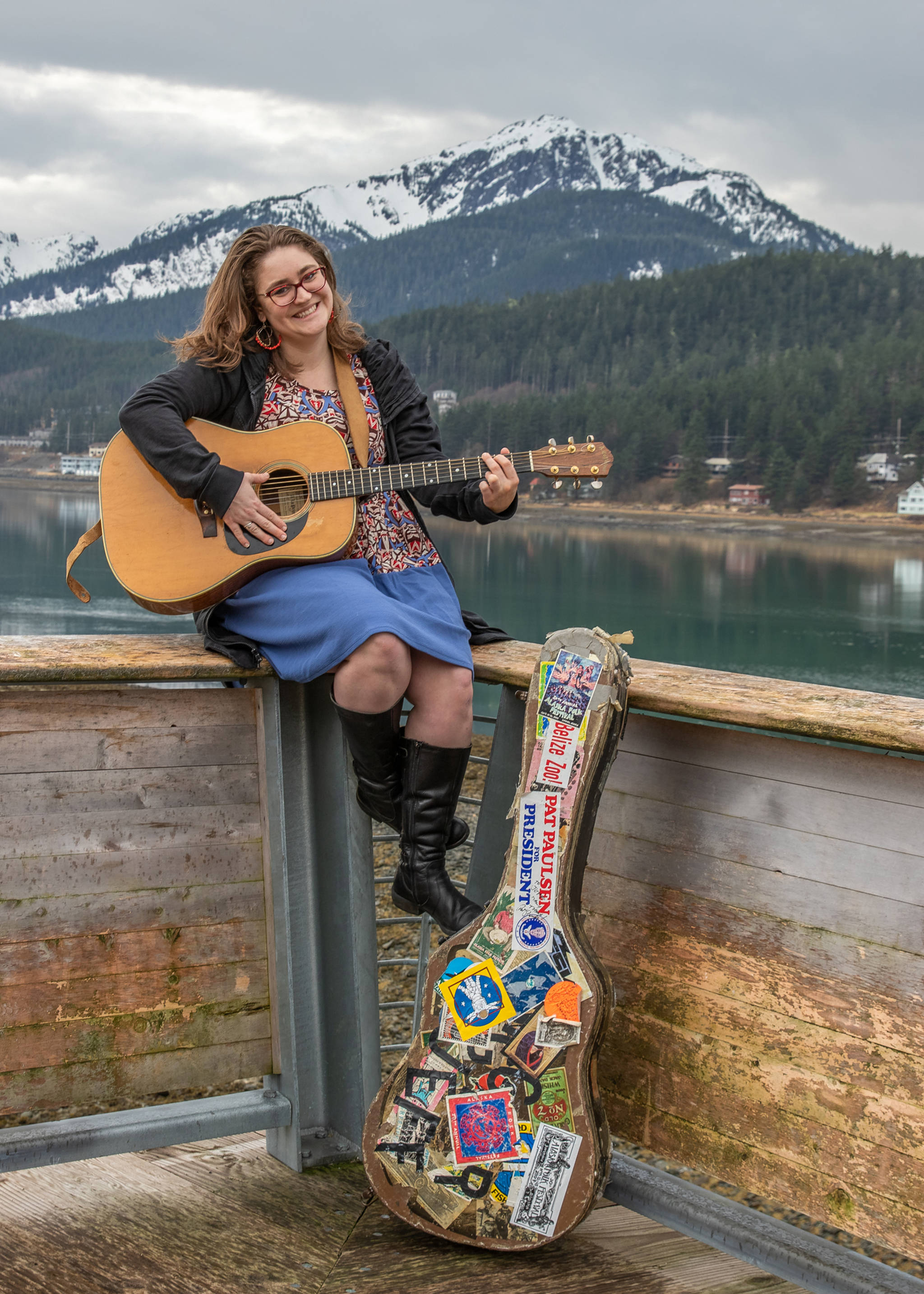 April 14, 2019: The Alaska Folk Festival has a style all its own as does Callie Conerton. Callie first appeared on stage at this annual event when she was 2 years old and has played on stage there many times since. This day she wore a colorful empire waist dress from LuLaRoe, a black jacket from Prairie Grass, and black leather boots from Bos. & Co. Her essential accessories include her red glasses, red and gold beaded hoop earrings that her mom Maureen Conerton got while traveling, and an A LoPrinzi guitar that belongs to her dad Jeff Brown, which has been played in every Folk Fest since 1975.