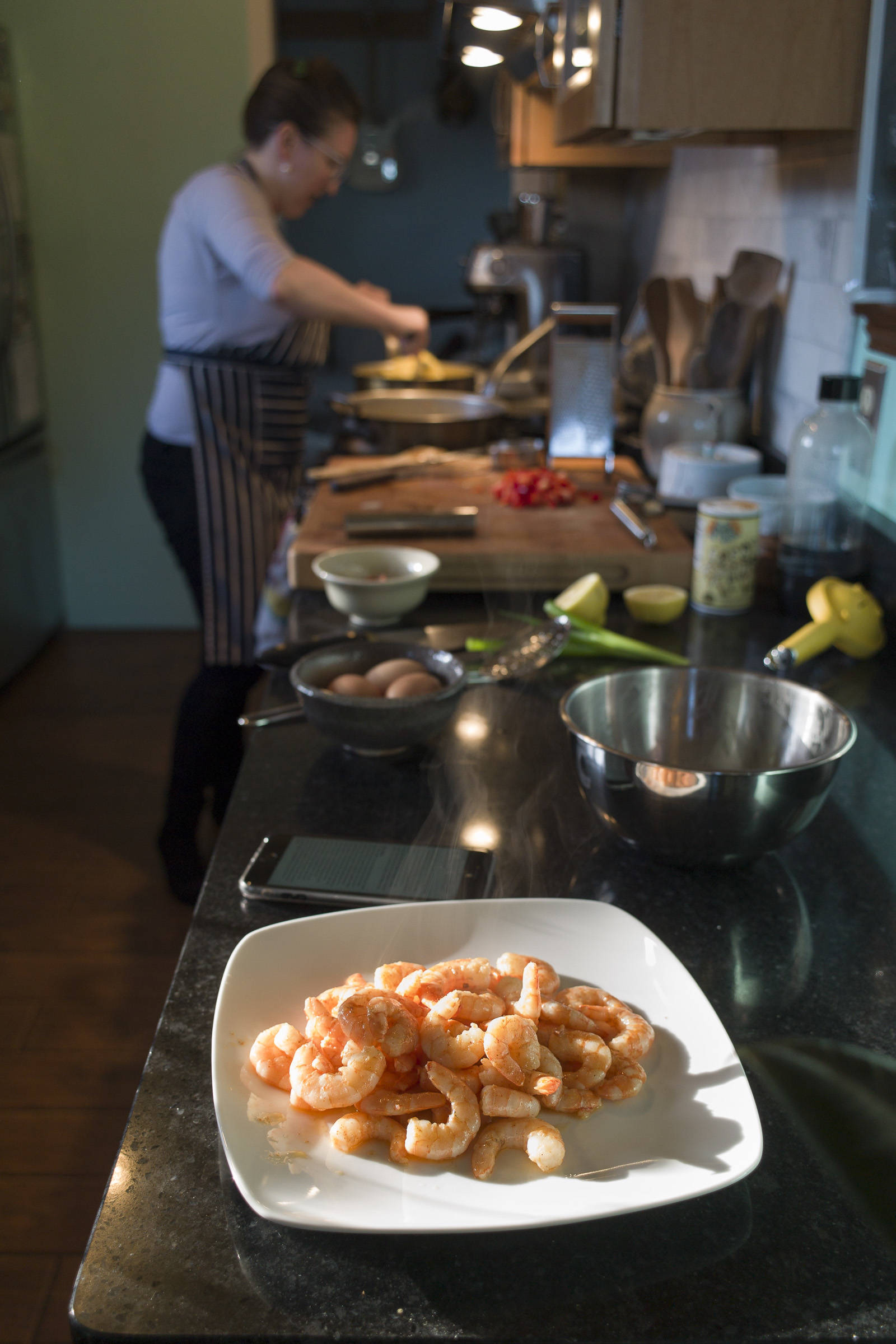 Erin Anais Heist prepares a spaghetti squash, prawns, bacon and egg breakfast dish in her home kitchen on Thursday, March 28, 2019. (Michael Penn | Juneau Empire)