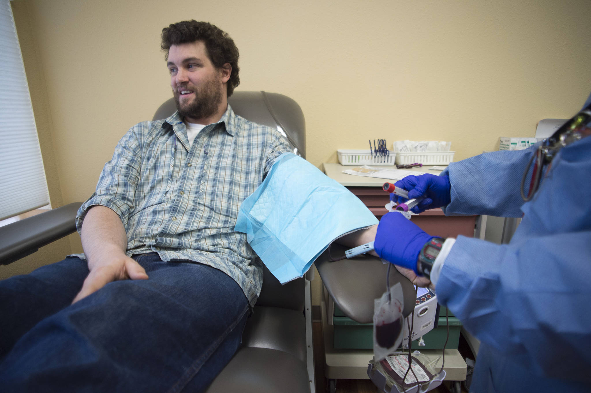 Quincy Judson relaxes as he donates blood at the Blood Bank of Alaska’s new permanent Juneau office in the Jordan Creek Center on Thursday, Jan. 10, 2019. (Michael Penn | Juneau Empire)