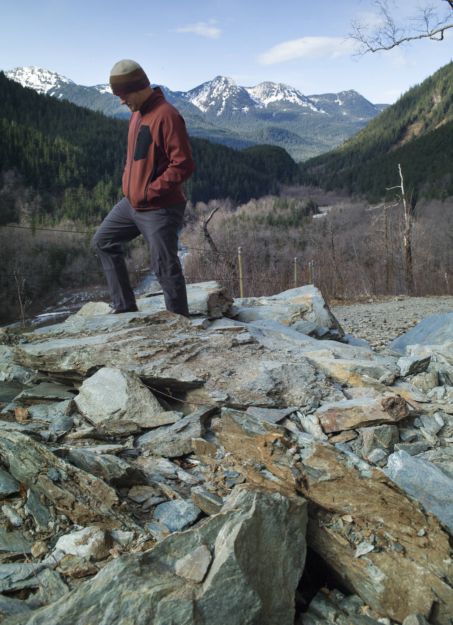Eric Christensen walks over fallen rock on Perseverance Trail on Tuesday, March 26, 2019. (Michael Penn | Juneau Empire)