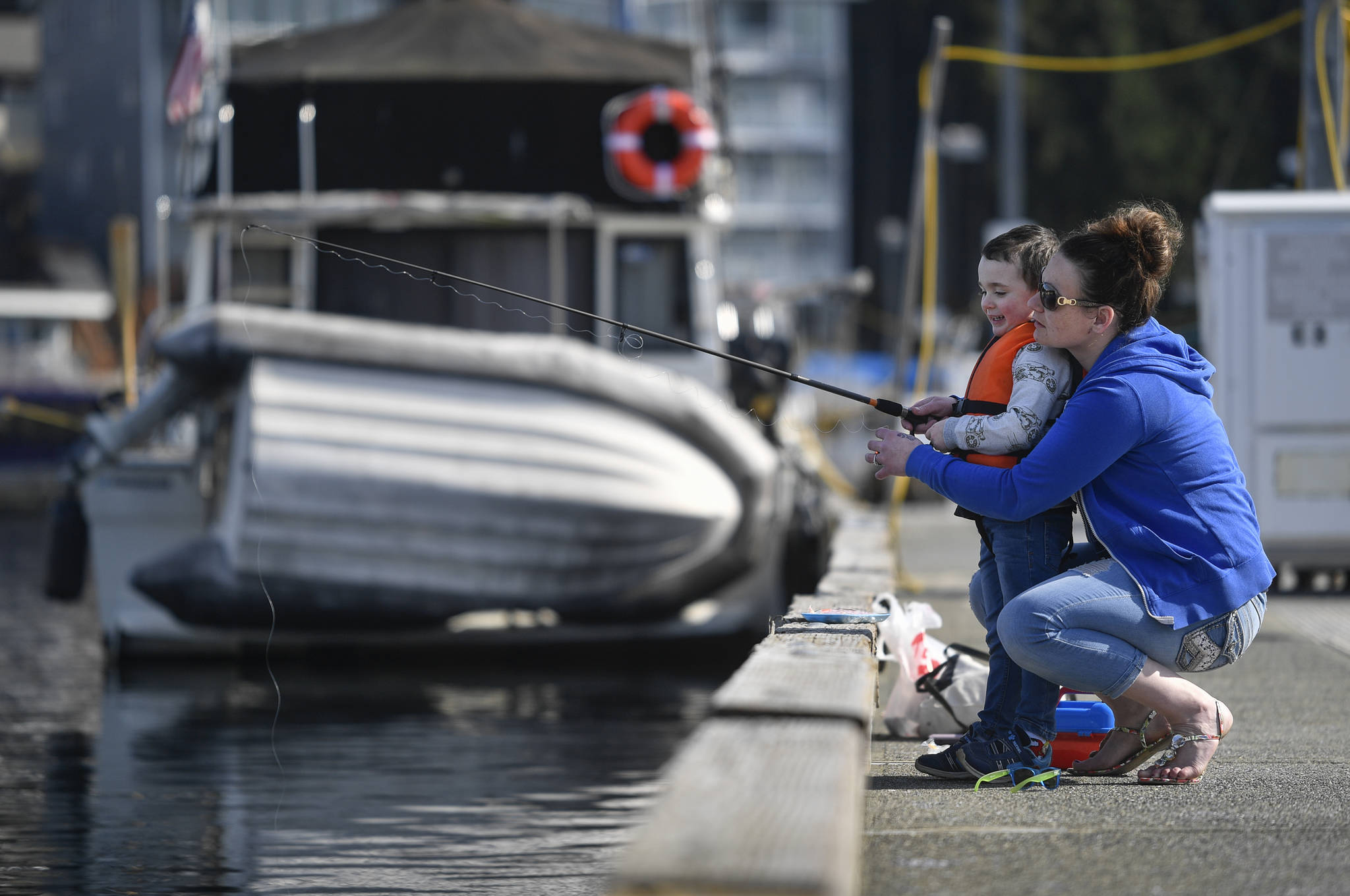 Taylor Kesterson fishes with her son, Malakai, 5, at the Don D. Statter Memorial Boat Harbor in Auke Bay on Tuesday, April 2, 2019. Kesterson said she fished from the dock as a child and wanted her son to have the same experience. (Michael Penn | Juneau Empire)