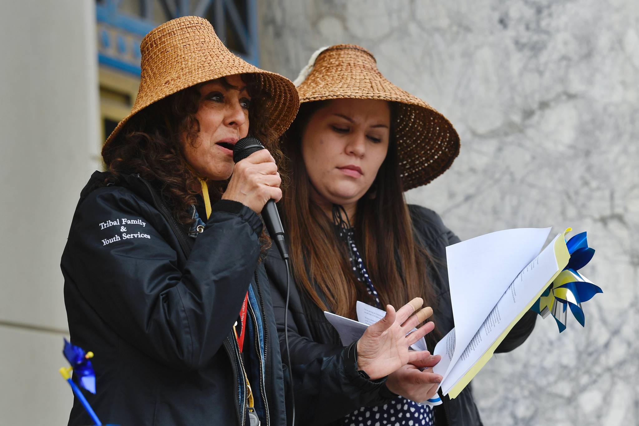 Amalia Monreal, Child and Family Clinician for the Central Council of the Tlingit and Haida Indian Tribes of Alaska, left, and Barbara Dude, Family Services Administrator, speak during a Go Blue Day Rally for National Child Abuse Prevention Month at the Capitol on Friday, April 5, 2019. (Michael Penn | Juneau Empire)