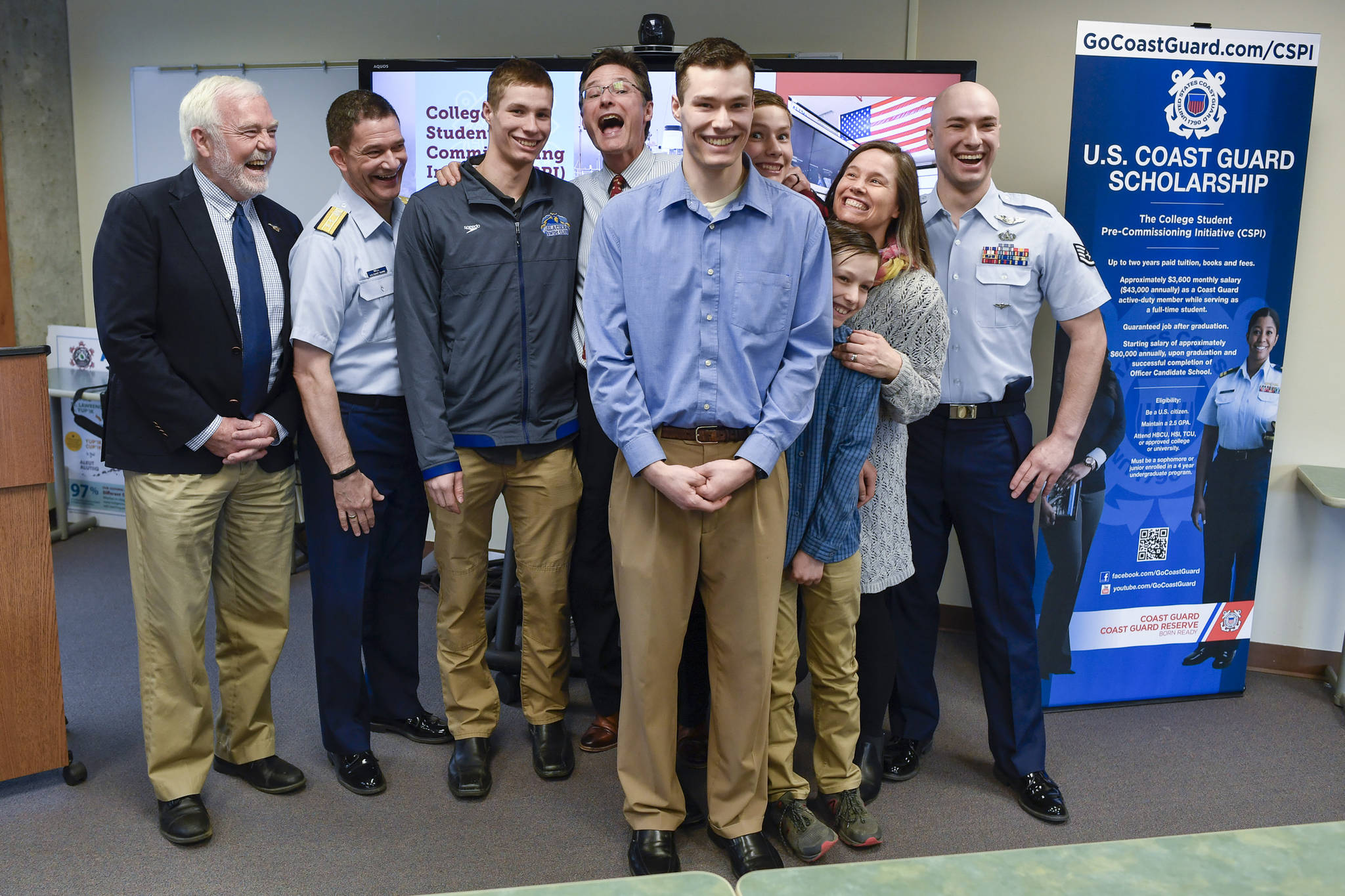 Logan Holt, 21, a business major at the University of Alaska Southeast, is surrounded by his family after being sworn into the U.S. Coast Guard by Rear Admiral Matthew Bell Jr., commander of the 17th Coast Guard District, second from left, and watched by UAS Chancellor Rick Caulfield, left, at UAS on Tuesday, April 9, 2019. Holt is the first recruit from UAS to be accepted into the Coast Guard’s College Student Pre-Commissioning Initiative program. (Michael Penn | Juneau Empire)