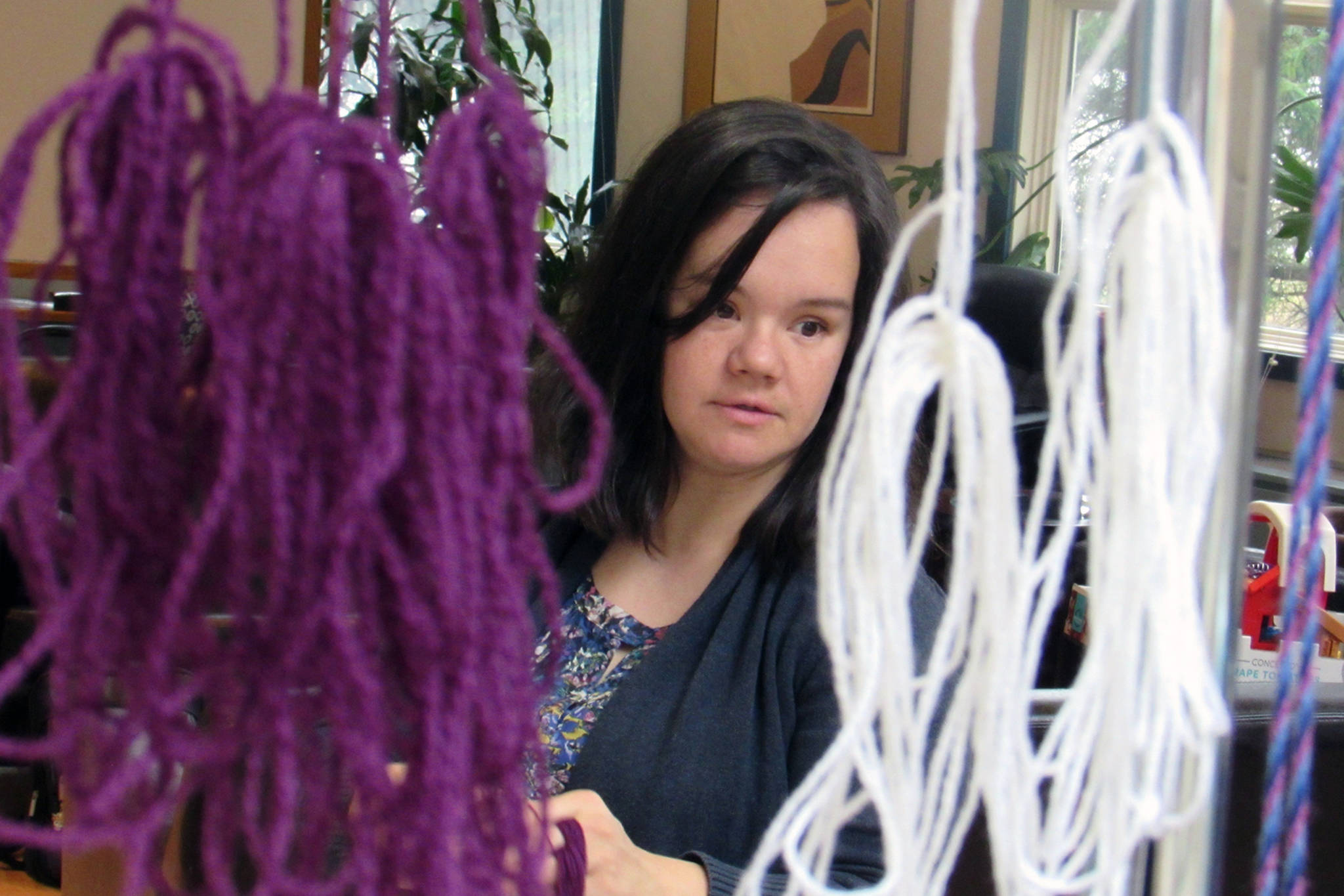 Weaver Lily Hope peers through materials while discussing the Giving Strength Robe project, a collaborative effort meant to honor survivors of violence, Friday, April 12, 2019. (Ben Hohenstatt | Juneau Empire)